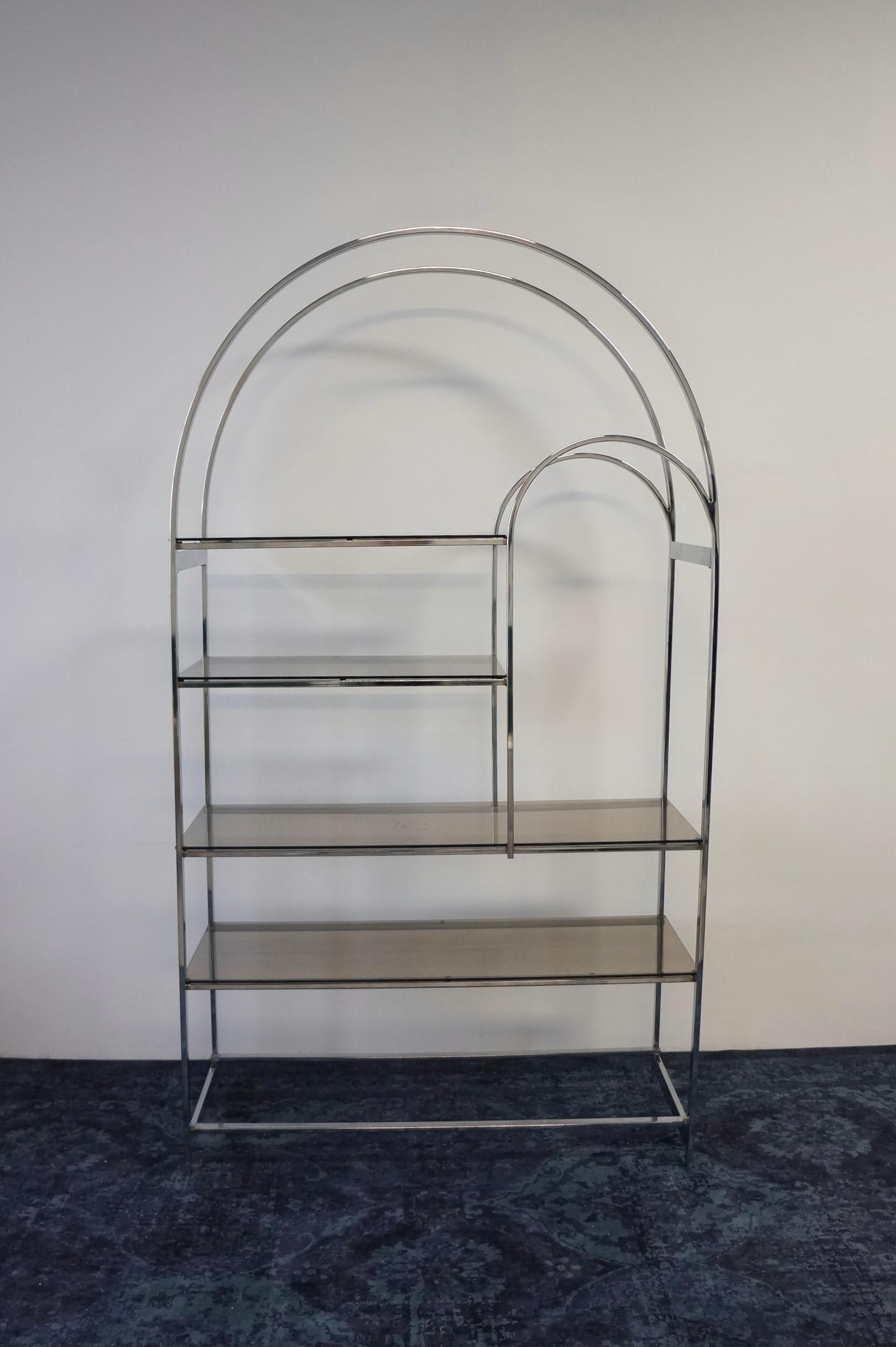 Stunning chrome and smoked glass arch etagere made in the 1970s. This mid century modern arch etagere is finished in chrome and has smoked glass shelves. A spectacular etagere that would complement various styles and the perfect piece for additional