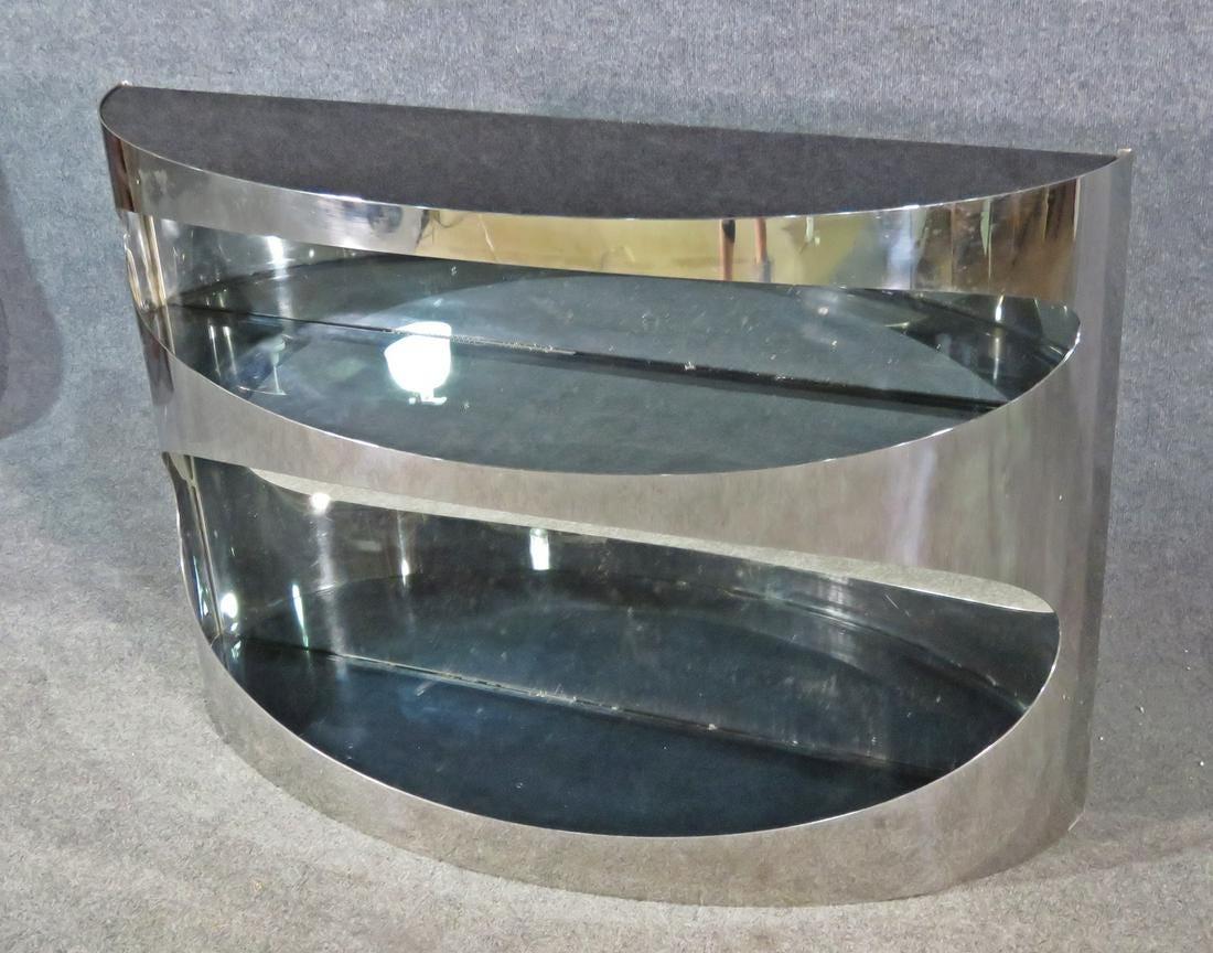 Unique and striking, this console table is styled after the designs of Pierre Cardin. Chrome and smoked glass are paired beautifully to give this table an eye-catching appearance. Please confirm item location with seller (NY/NJ).