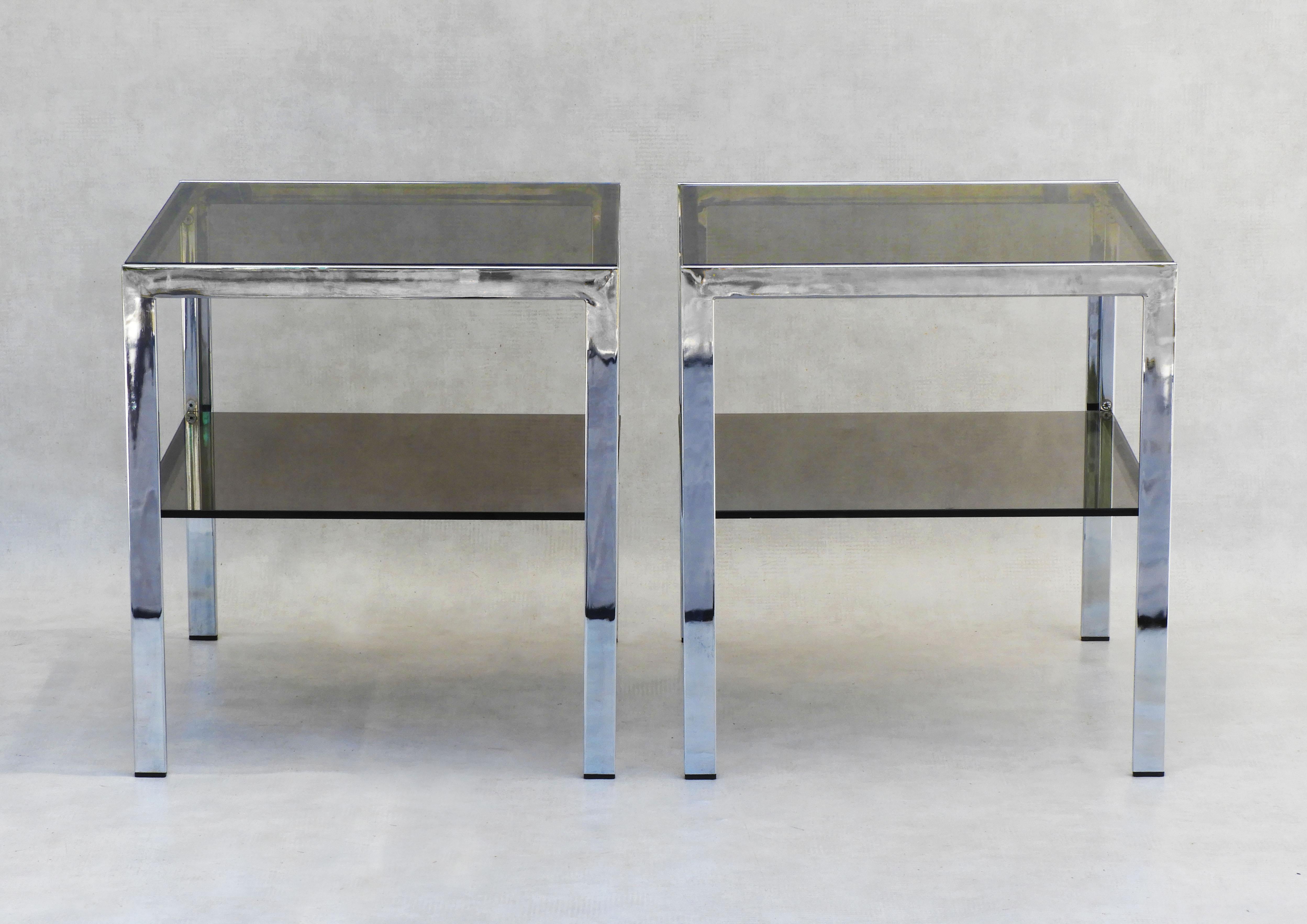 Vintage French Chrome and smoked glass side tables c1970.
A pair of stylish two tiered tables that can be placed as occasional tables, sofa end tables or nightstands.  Classic 70s French design with sleek simple lines that work well in a large array