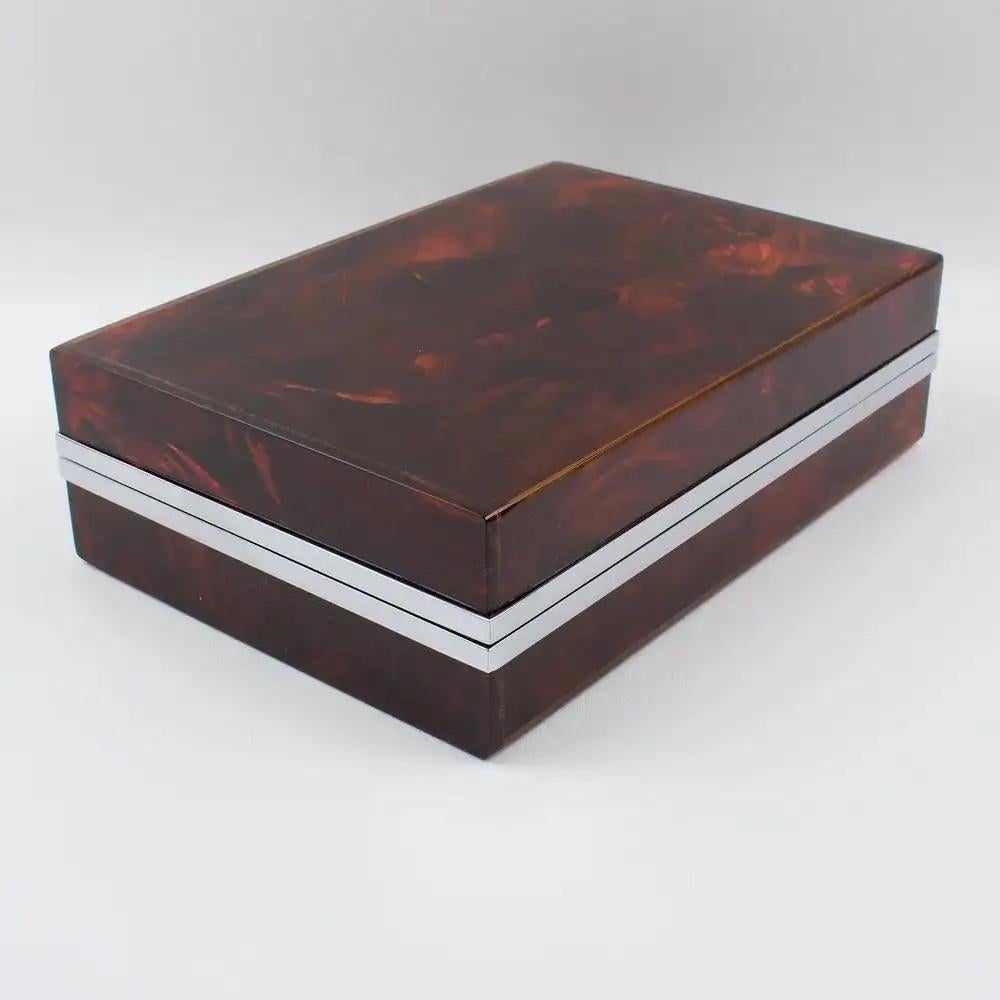This decorative lidded box is perfect for living space or vanity and was crafted in the 1970s. The piece boasts a chrome-plated framing with Lucite in a tortoiseshell (tortoise) textured pattern. With impressive quality and a lovely translucent