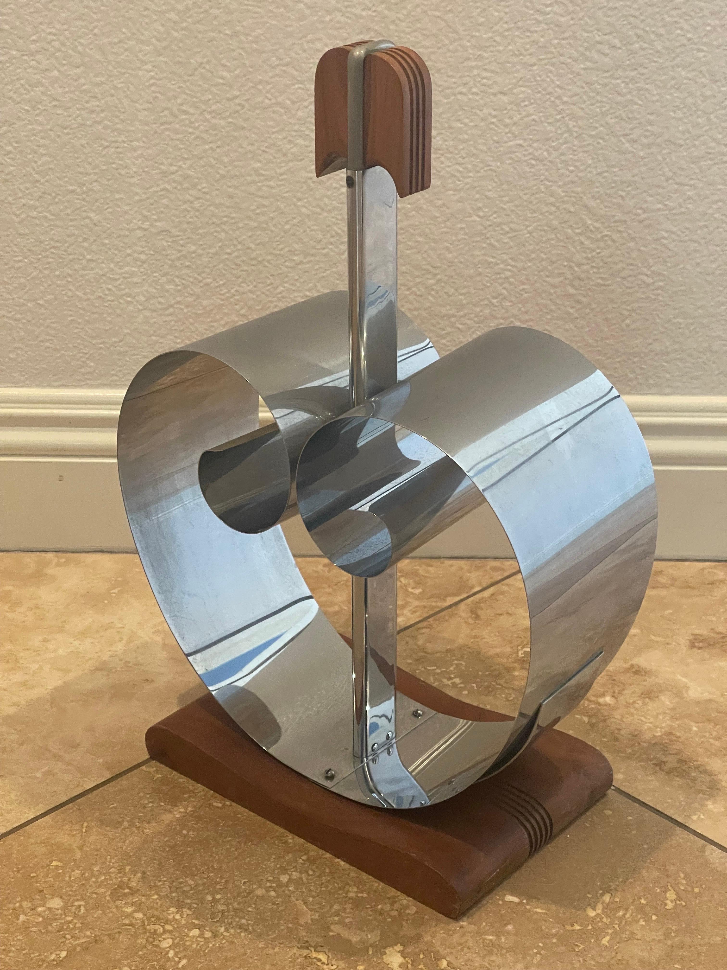 A chrome and walnut Art Deco magazine rack by Fred D. Farr for Revere, circa 1930s. This spring design concept was first used by Farr in his hugely successful range of bookends for Revere. This piece is one of the original magazine versions issued