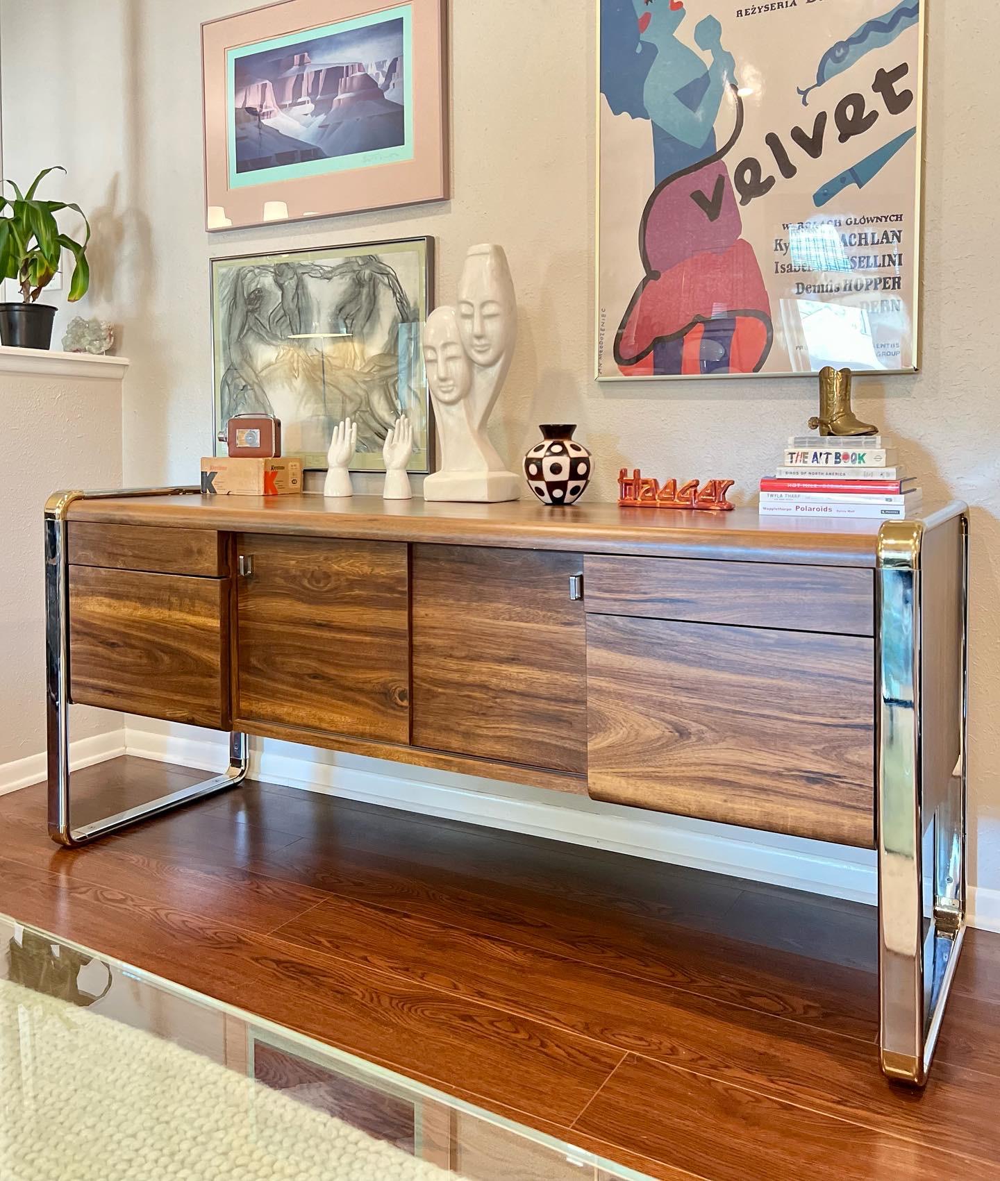 Stunning Mid-Century Modern credenza in the style of Peter Protzman for Herman Miller. This piece is extremely heavy and high quality. The credenza is suspended by the chrome frame on the sides and covered in a walnut veneer that is still in great