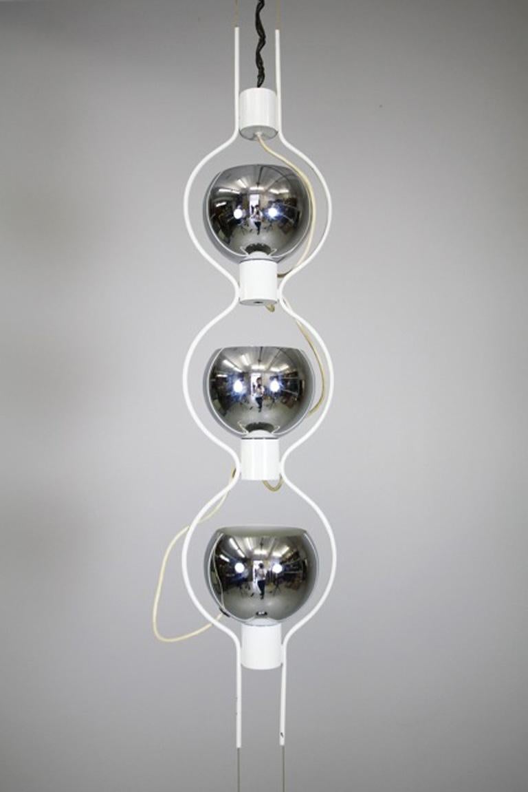 Questa rarissima, complessa ma semplice lampada da soffitto '14071' di Angelo Lelli è realizzata in metallo cromato e laccato bianco. Ha tre sorgenti luminose che provengono da coni sferici e rotondi. La lampada è bilanciata da un peso anch'esso