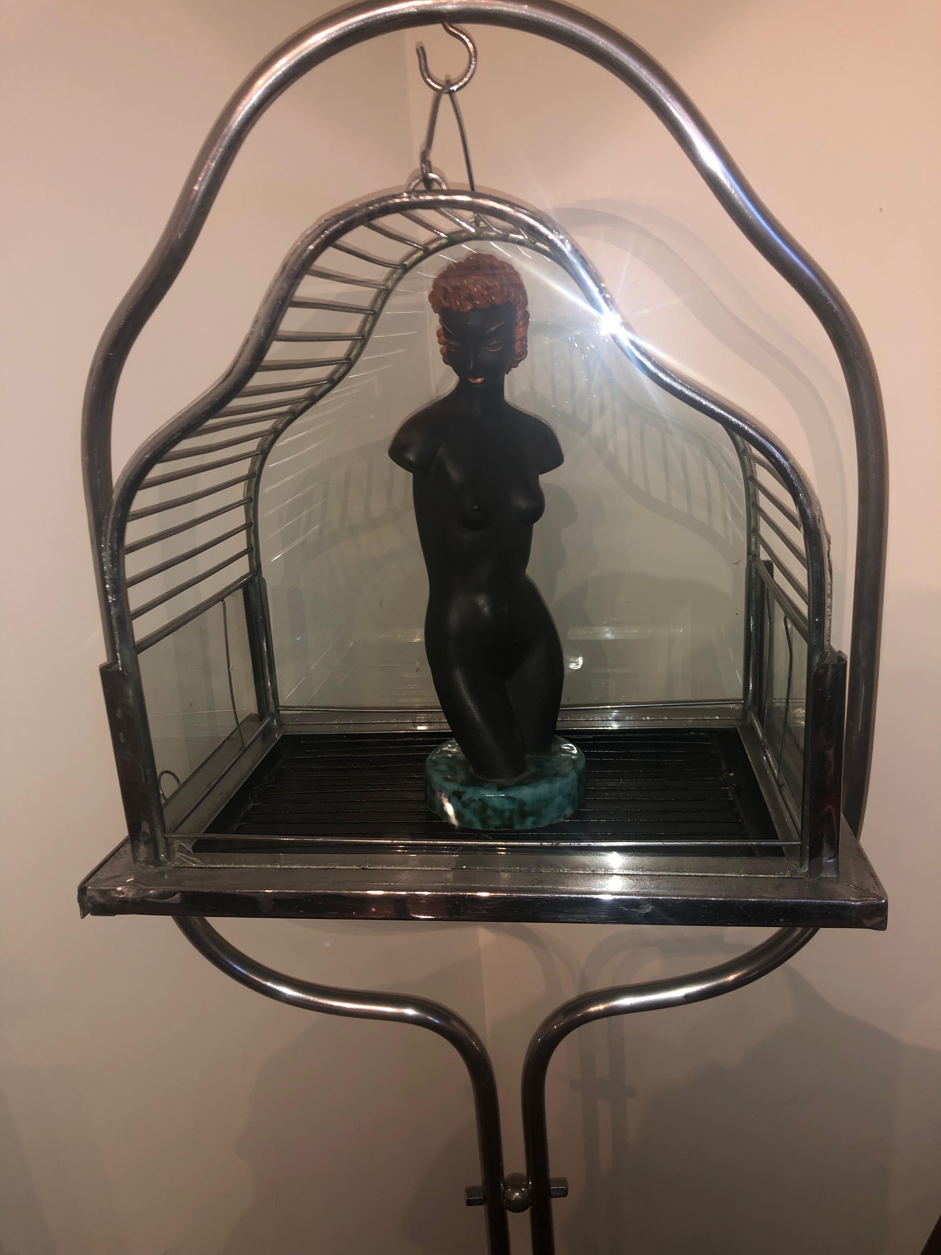 Art Deco bird cage on stand. Simple chrome details with modern Bauhaus base design. This is in very nice original condition, with a typical gate or door entry. Front and back glass shapes outline the cage with simple rectangular glass on the outside