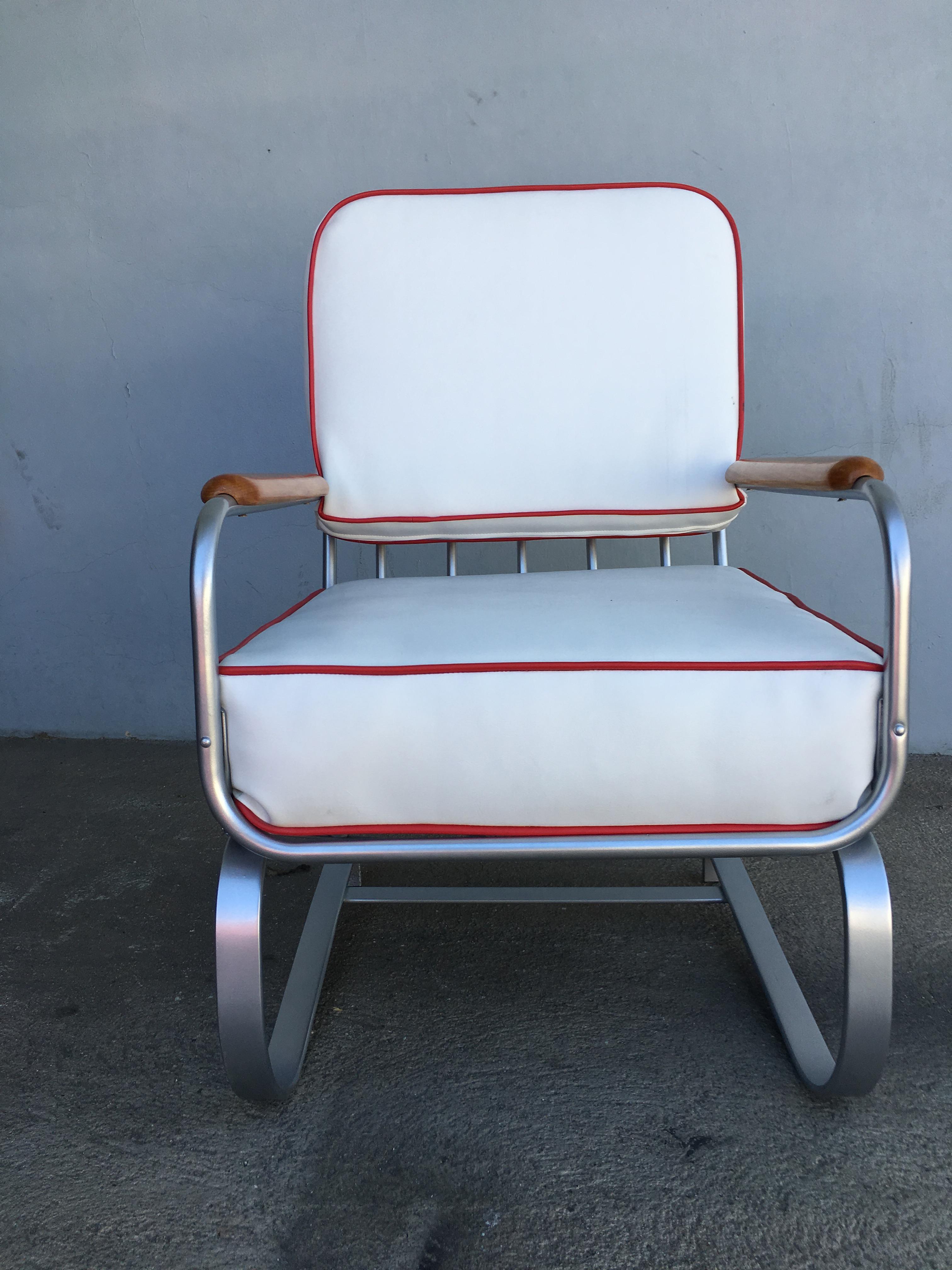 Verchromter Art-Déco-Sessel, bestehend aus einem verchromten Gestell, das sich nahtlos in die Form der flachen Eisenbeine, der Arme und der Rückenlehne des stromlinienförmigen Sitzes einfügt. Die Armlehnen sind mit leicht gebeiztem Nussbaumholz