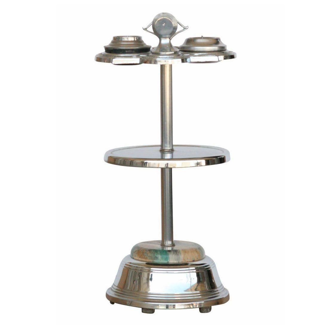 Original chrome Art Deco two-tier ashtray stand featuring a decorative chrome body and swirl glass accent along the base with 3 ashtrays and an electric lighter. The stand has a shelf in the middle for holding tobacco jars, cigarettes, matches, or