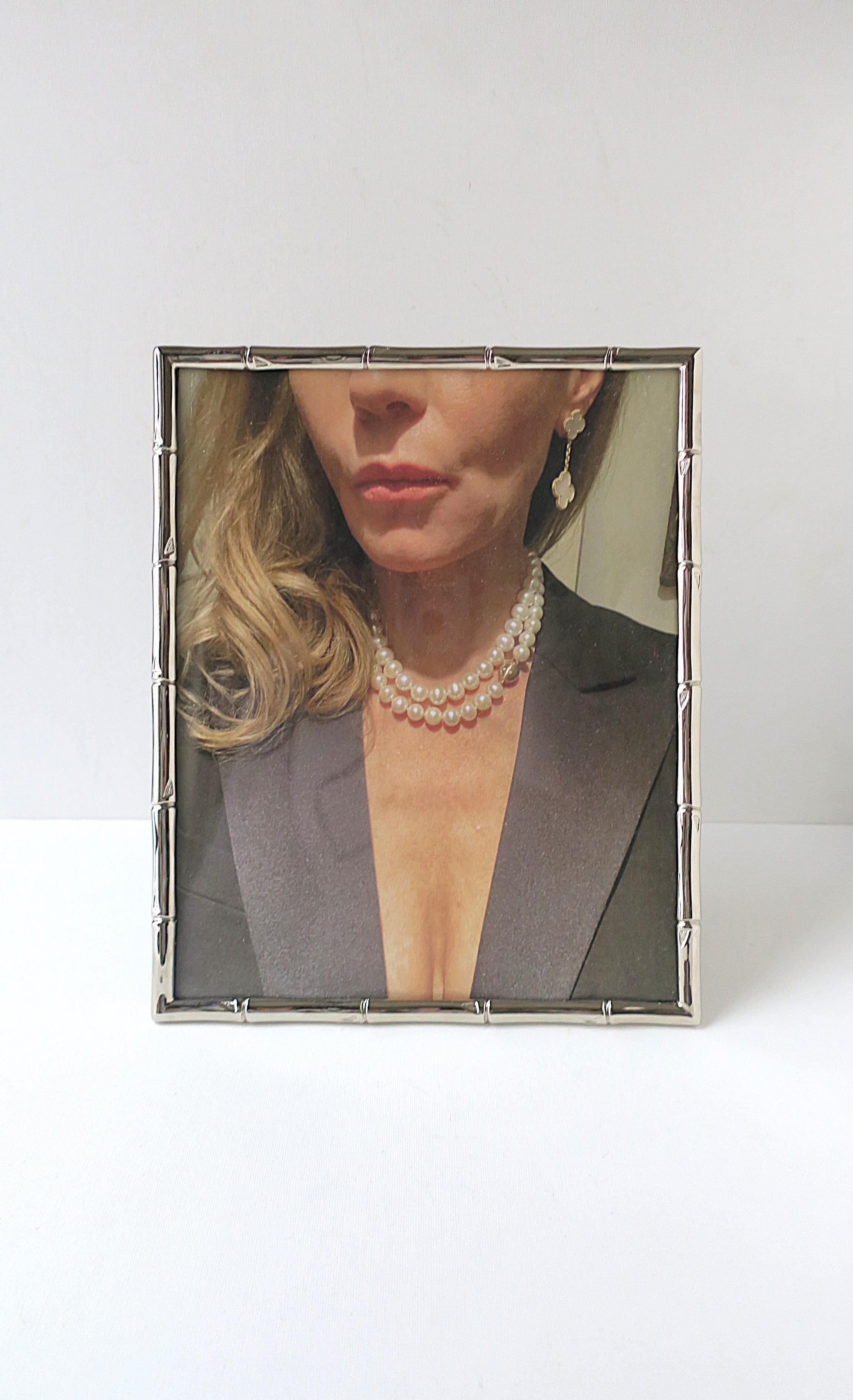 A relatively large chrome 'bamboo' motif picture frame in the style of Gucci Home, circa late-20th century. Frame can sit vertical or horizontal, as demonstrated. Picture window area measures: 7.75