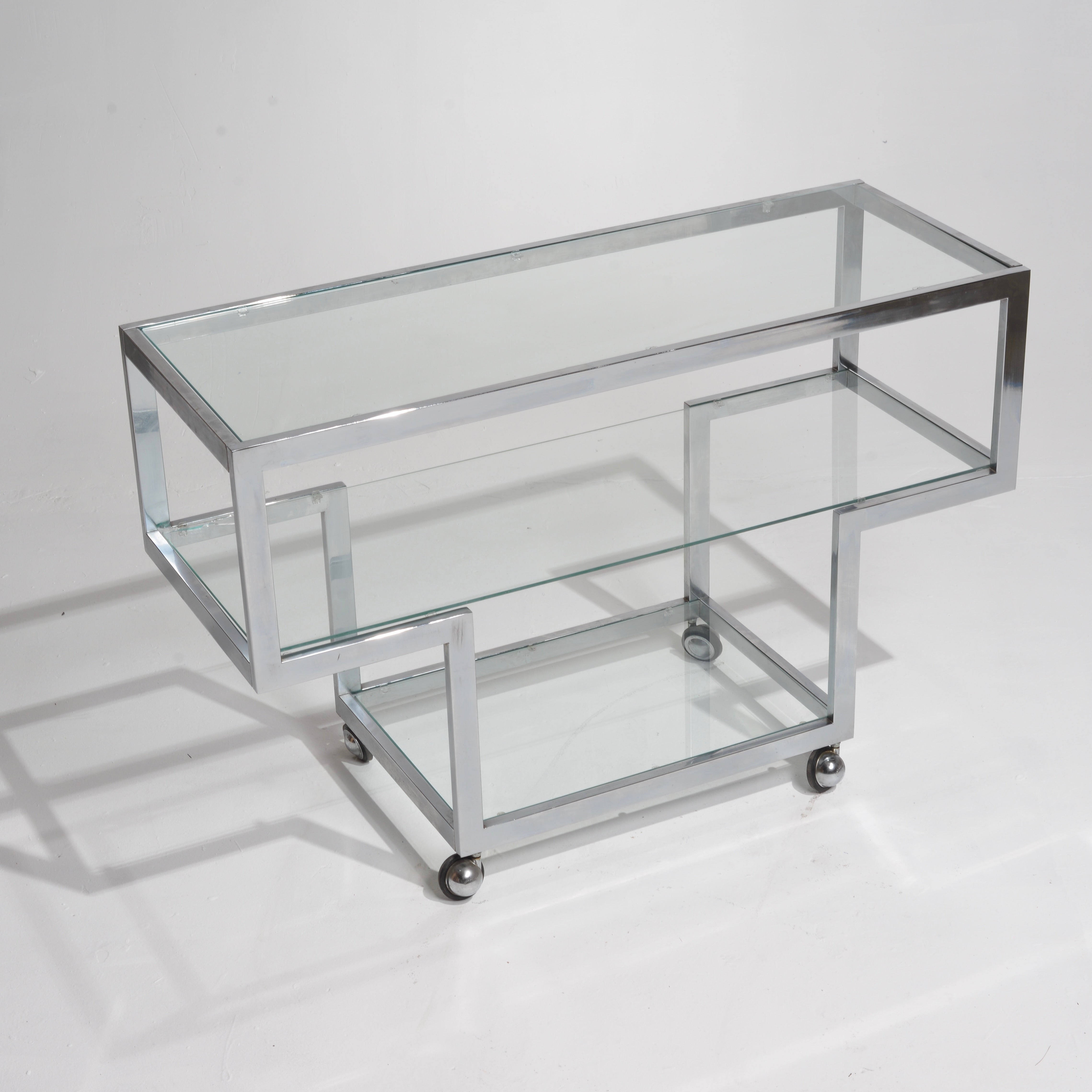 This is an amazing post-modern chrome and glass rolling bar cart or console.  