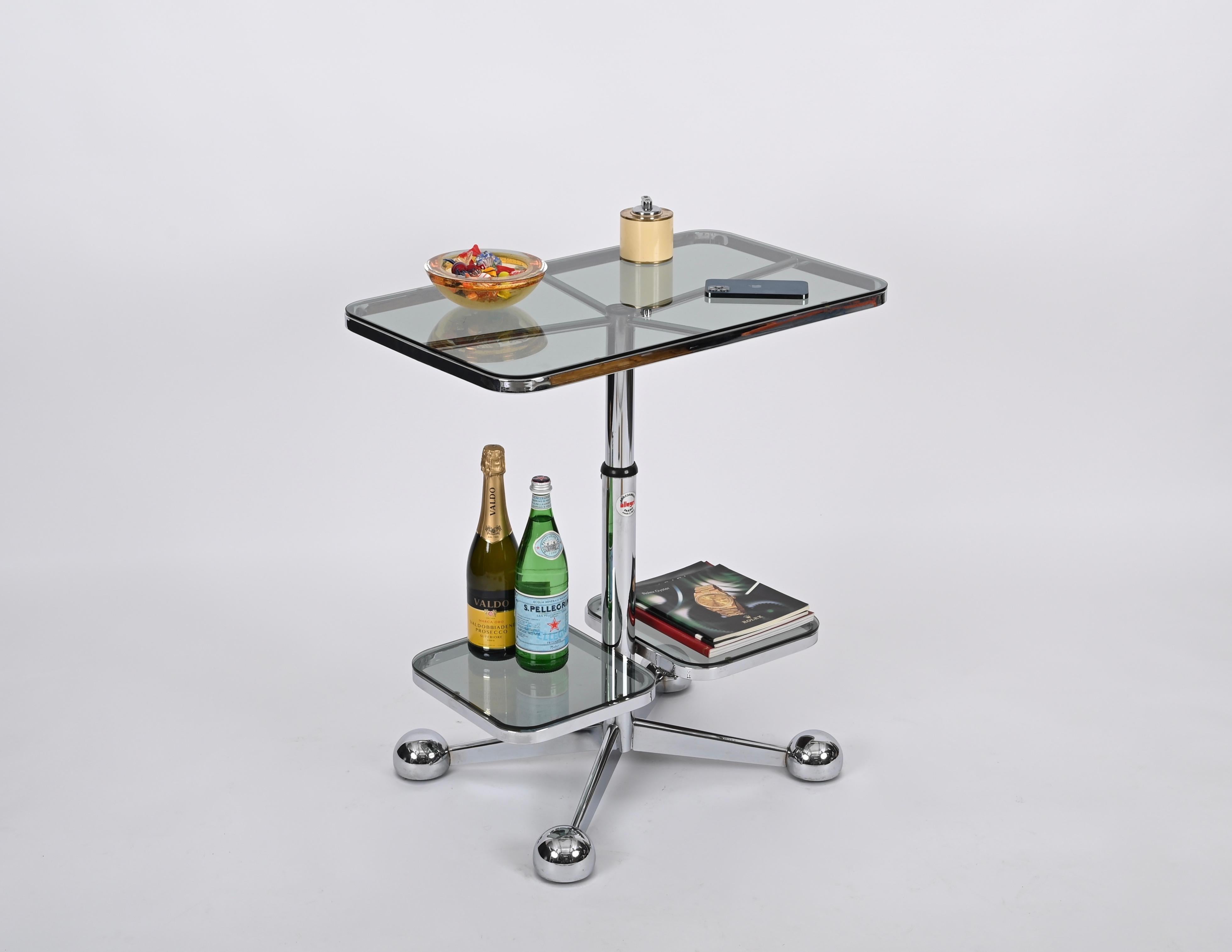 Stunning adjustable bar trolley table produced by Allegri Arredamenti in Parma, Italy, during the 1970s.

This serving table is fully made in chrome with a top and two lower trays in smoked glass. The height of this stylish object can be regulated
