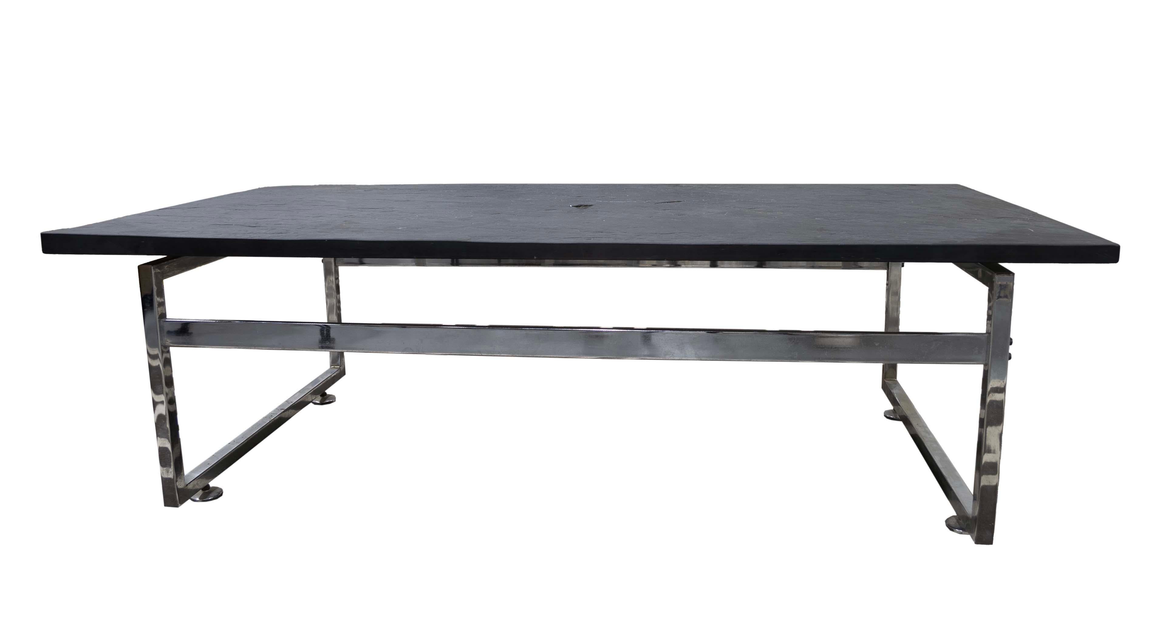 Élégante et sophistiquée, cette table basse à base chromée et plateau en ardoise noire ajoute une touche de modernité à tout espace de vie. Le design contemporain se caractérise par une base chromée robuste qui complète le plateau en ardoise noire