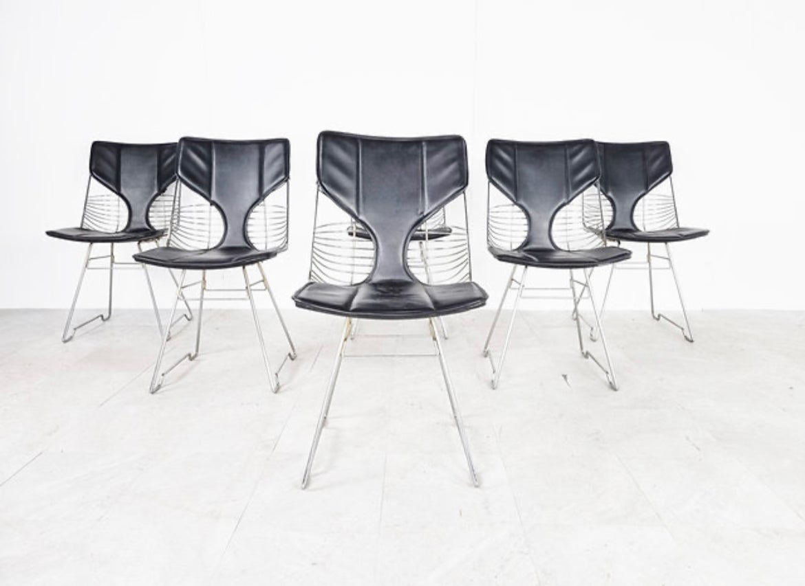 What a unique set of Italian 1970s dining chairs in the style of Gastone Rinaldi!! These are extremely striking with chrome wire featuring black leather cushions. These are good, heavy and solid quality dining chairs. Perfect with a marble dining