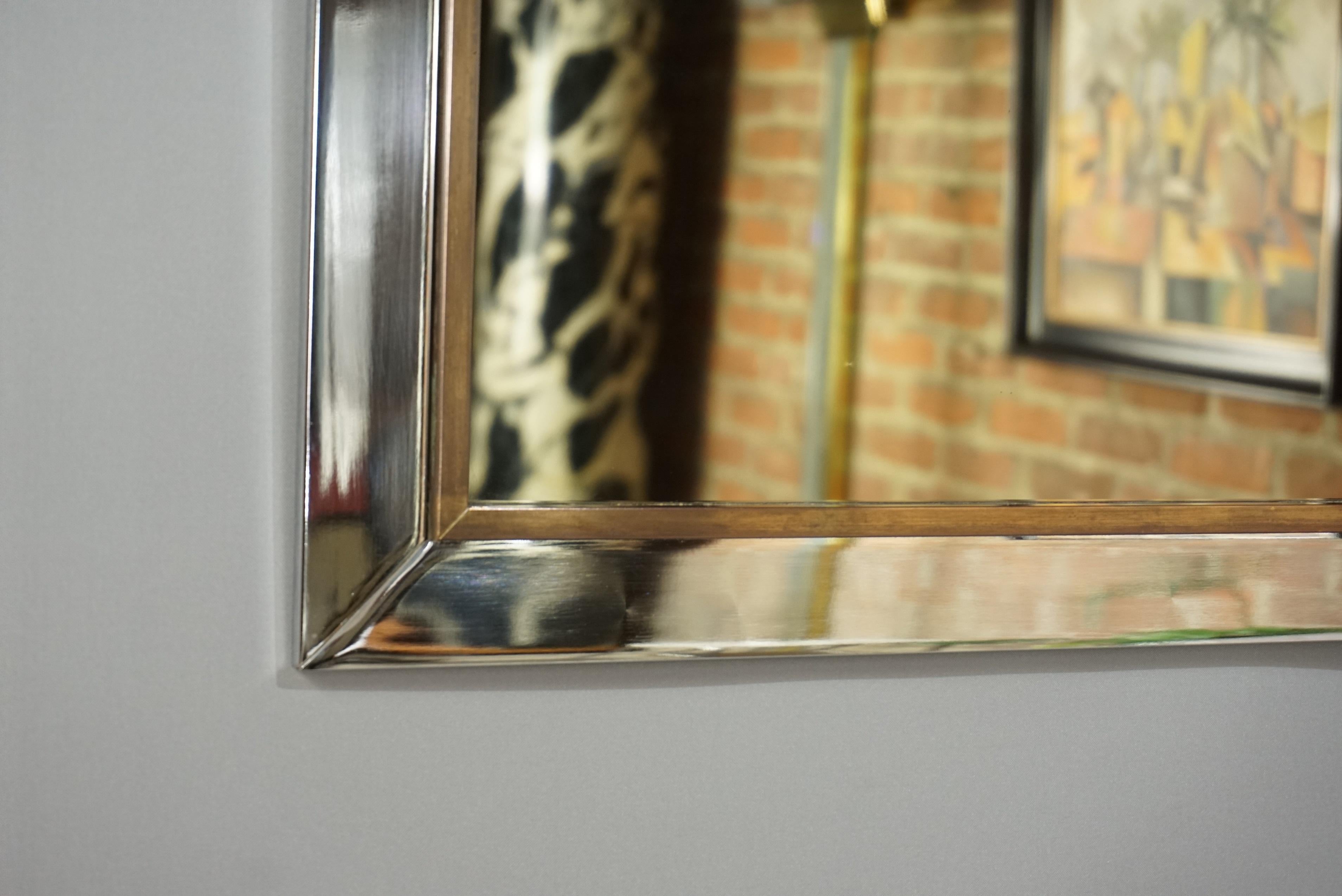 Presence and class for this minimalist bronze colored mirror, sober lines and design of the 1970s, chrome frame (mirror only 48 cm/ 98 cm), underlined with a patinated brass rod, dutch high quality by Belgo Chrom Design