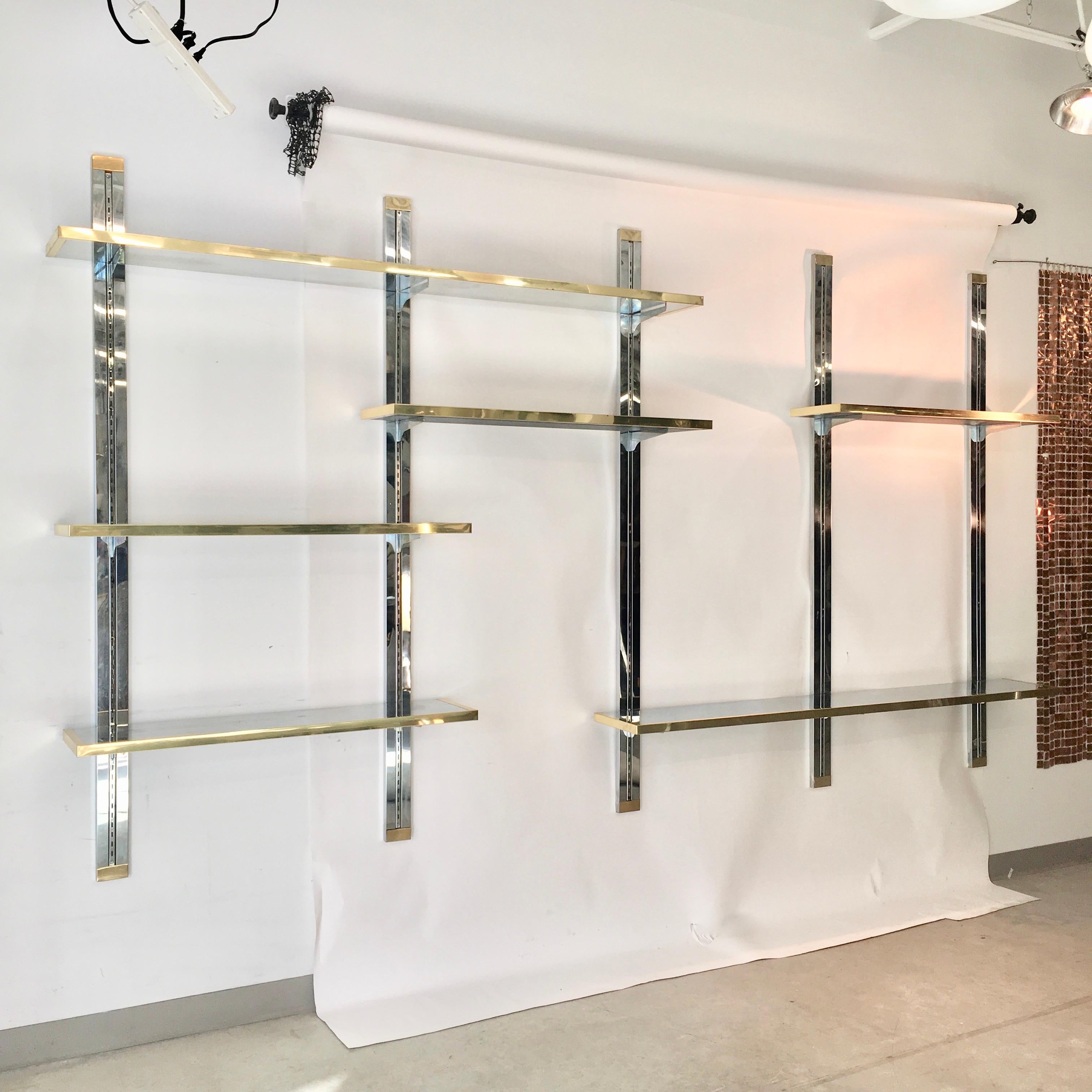 Blingy and glamorous 1970s custom made wall mounted shelves consisting of chromed steel single-track shelf standard which is embedded within a channel of a 75 inch length of 3 inch laminated wood which has been clad in mirror polished stainless