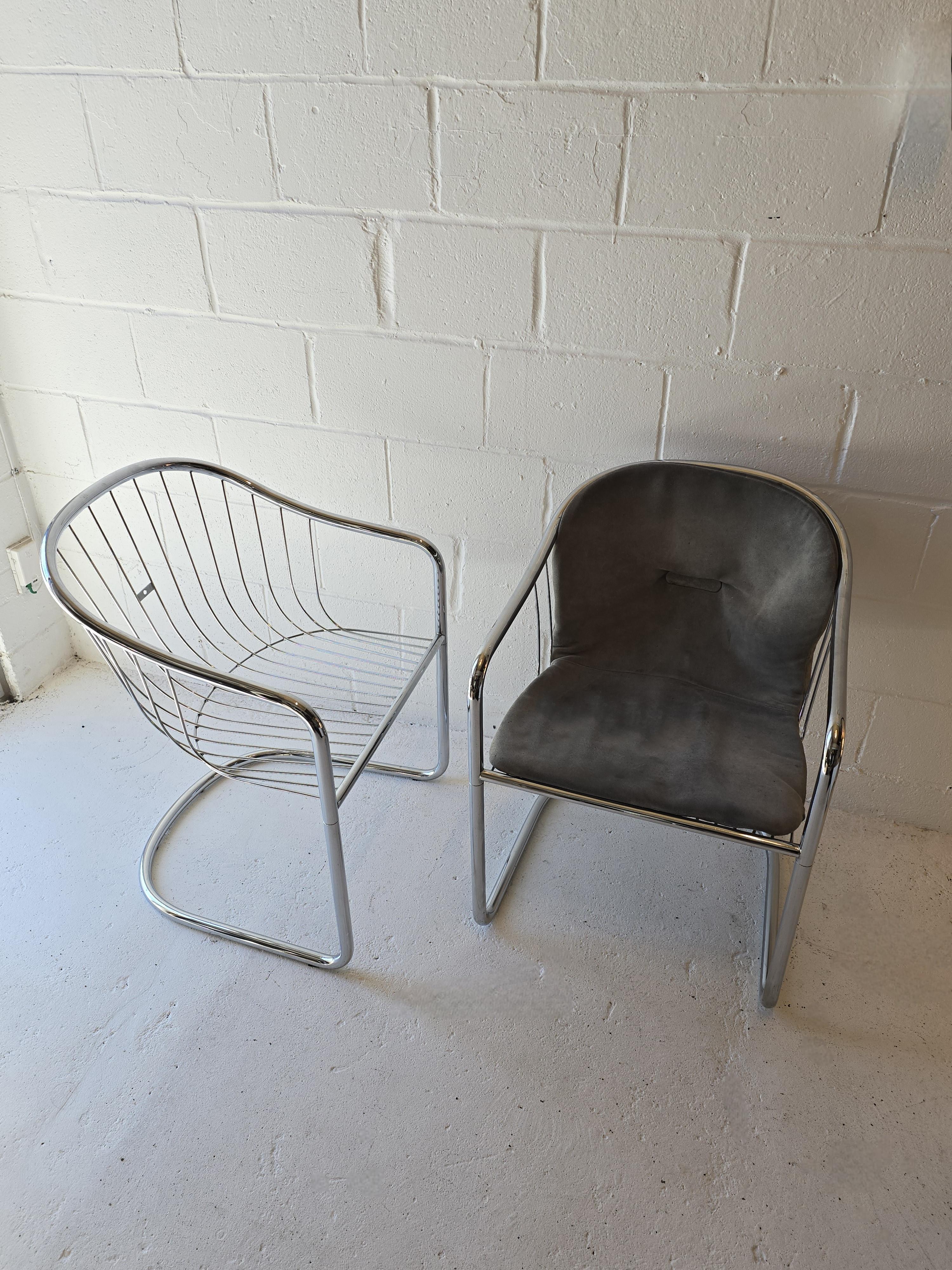 Catilevered chrome chairs attributed to  Gastone Rinaldi in the 1970s. This pair includes two arms which are rare to find. These timeless cantilever dining chairs are both comfortable and stunning. They’re made out of steel chrome and built to last.