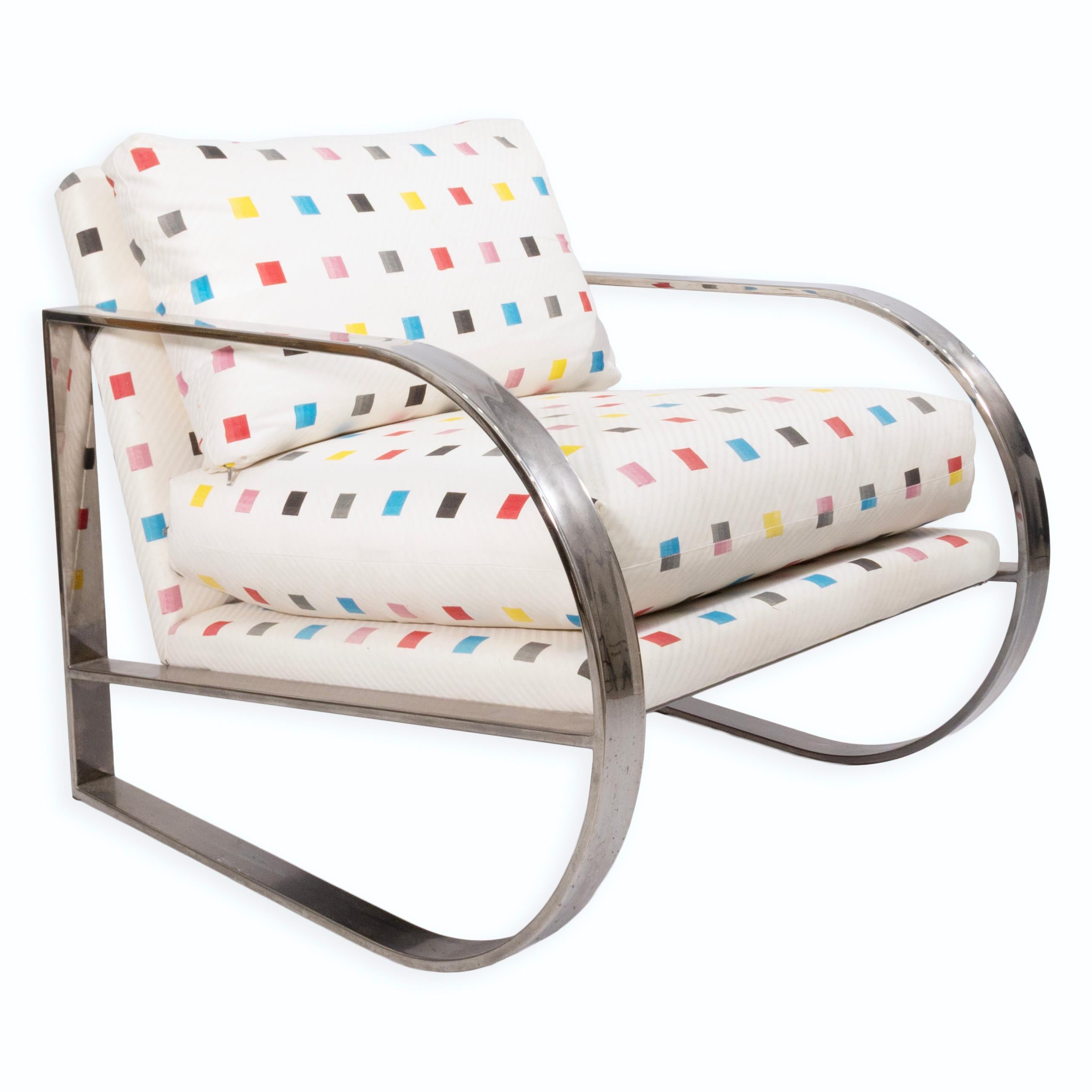 Questa audace poltrona lounge di Swaim abbina un'ampia struttura cromata a sbalzo con cuscini oversize rivestiti in un vivace tessuto geometrico. L'imbottitura bianca è decorata con quadrati multicolori sparsi che conferiscono un tocco postmoderno e