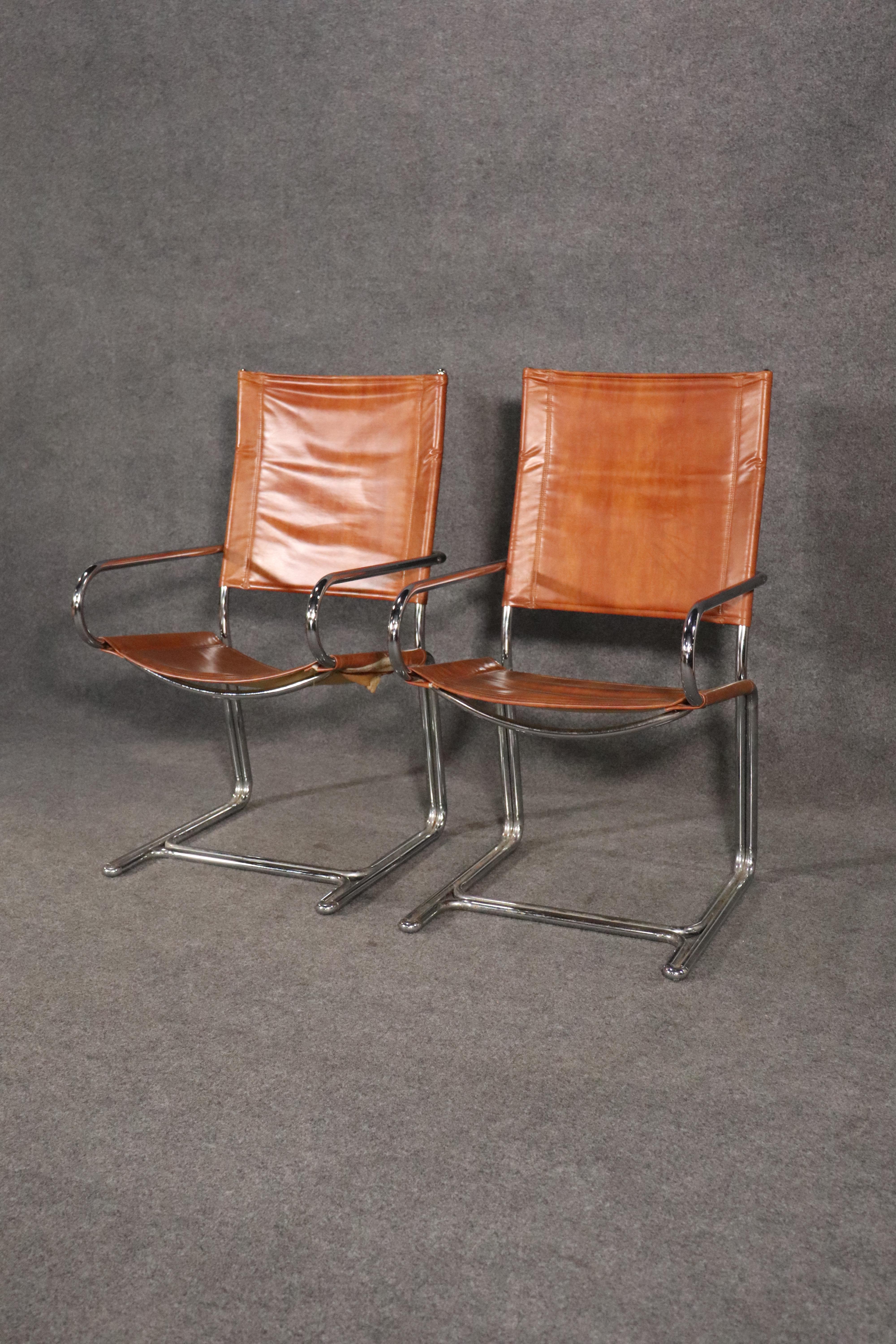Pair of mid-century modern arm chairs made by Cosco Home Products. Made of strong polished chrome frames, bent to go around the entire chair. Low profile arms, sling leather style fabric, sturdy and stylish.
Please confirm location NY or NJ