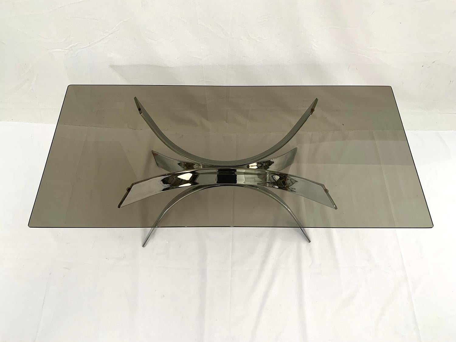 This beautiful coffee table is made of a chromed metal structure and a large smoked glass top.
It was designed in the style of Maria Pergay and dates from the 1970s.

Cette très belle table basse est composée d’une structure en métal chromé et