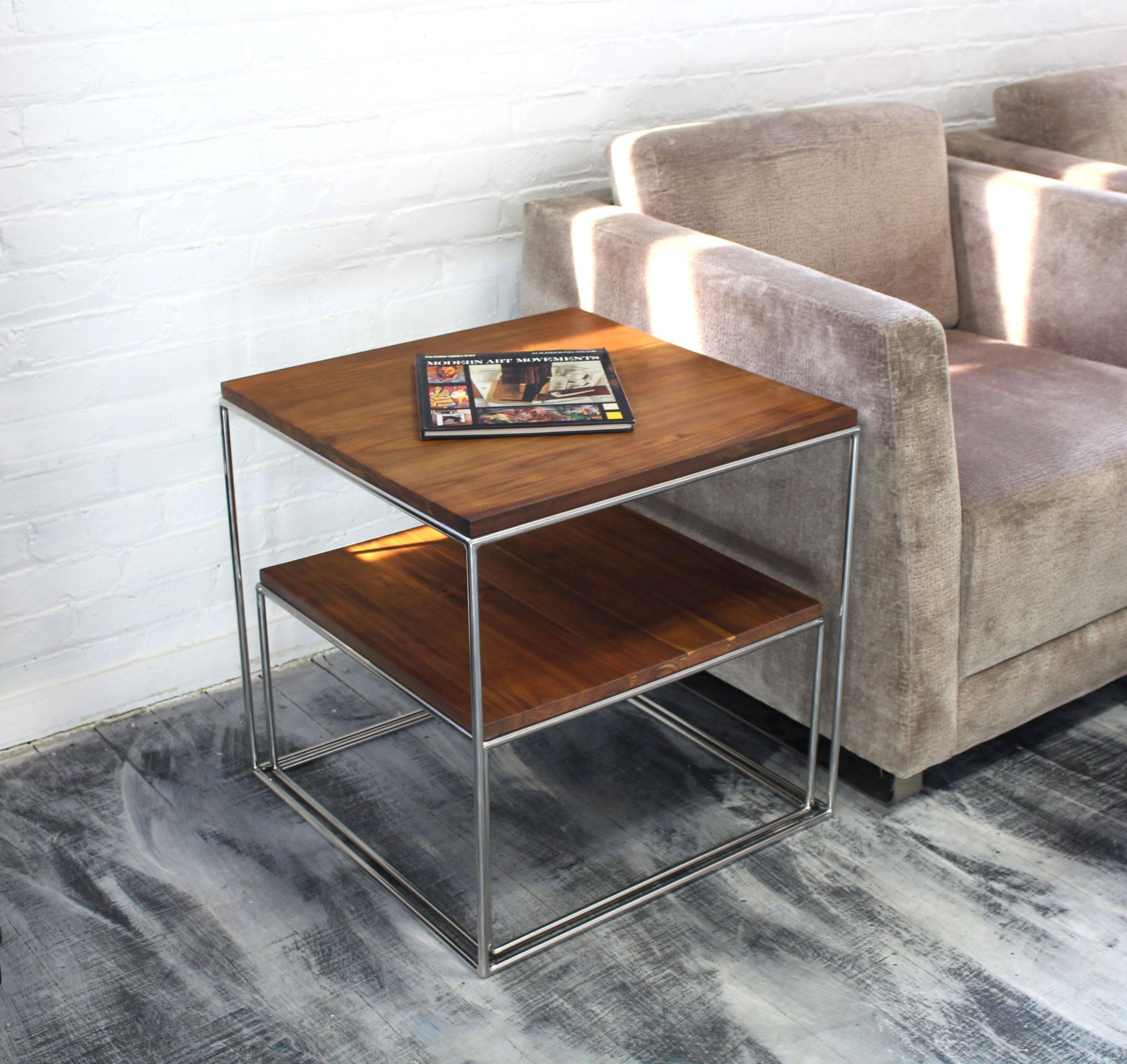 Established lines, Mid-Century Modern decor nesting end or side table. The cube shape table is a set of two nesting tables. The base is crafted out of solid stainless steel and the top is oil walnut finish solid acacia. The solid stainless steel rod