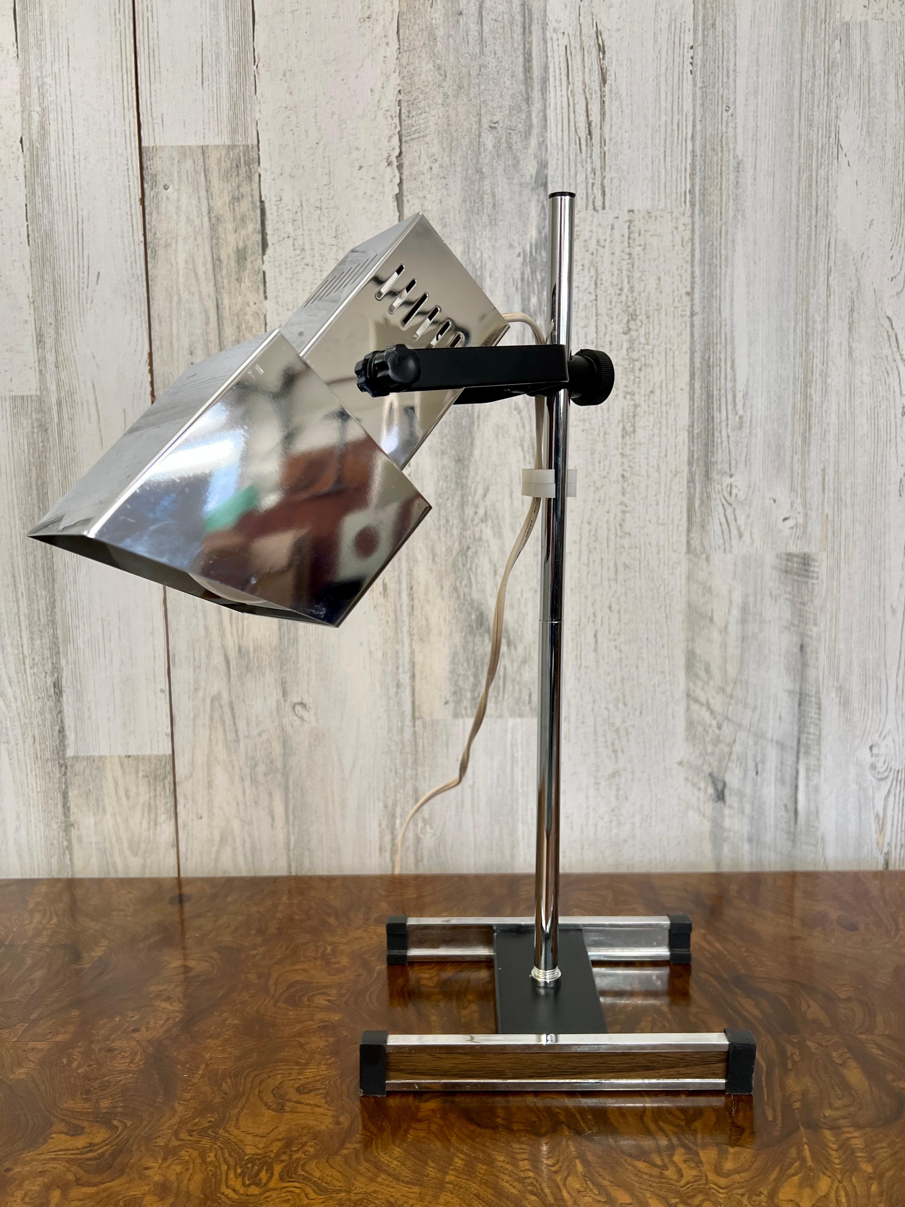 Der höhenverstellbare Stiel und der drehbare Würfel machen diese Lampe perfekt für einen Schreibtisch oder ein Bücherregal, auf dem Sockel ist das Holzlaminat zu sehen.