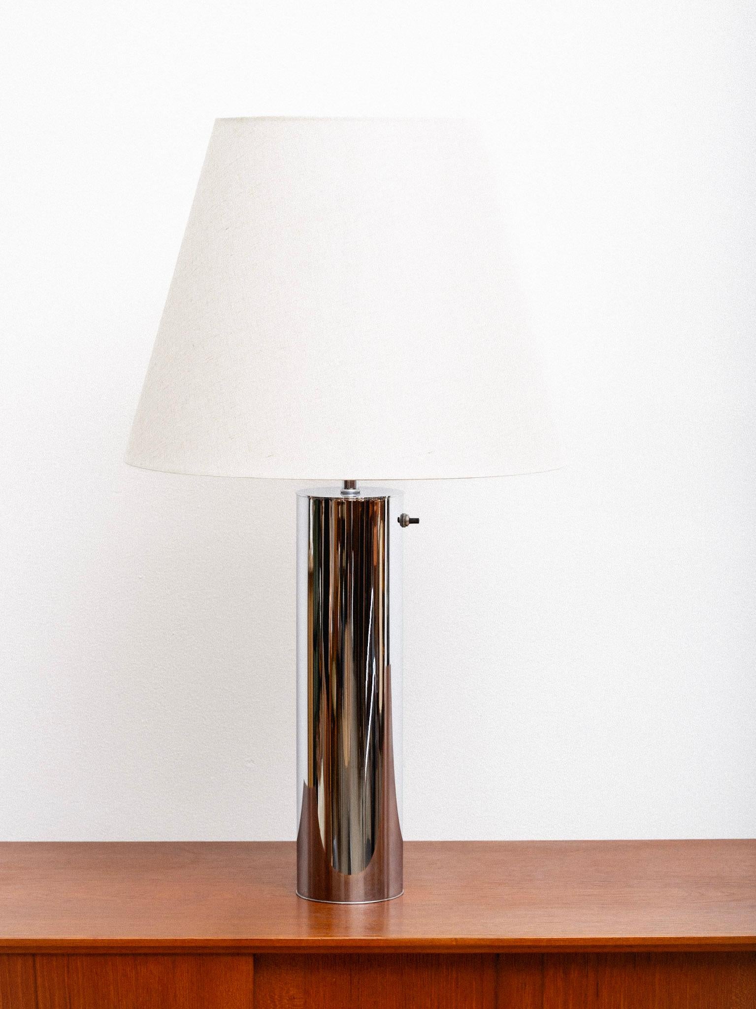 Lámpara de mesa cilíndrica de cromo pulido atribuida a Von Nessen. Interruptor de encendido/apagado cerca de la parte superior de la base. Pantalla de lámpara no incluida.

Von Nessen fue un diseñador de origen alemán que emigró a Estados Unidos en