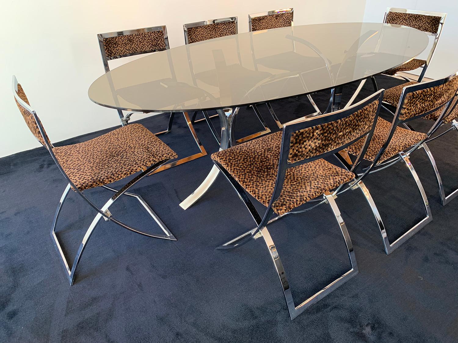 Beautiful dining room composed of eight folding chairs and a glass table, 1970. The set of folding chairs is designed by Marcello Cuneo in 1970 and produced by Mobel. The frame of the chairs is chrome and the seat and back are covered with the