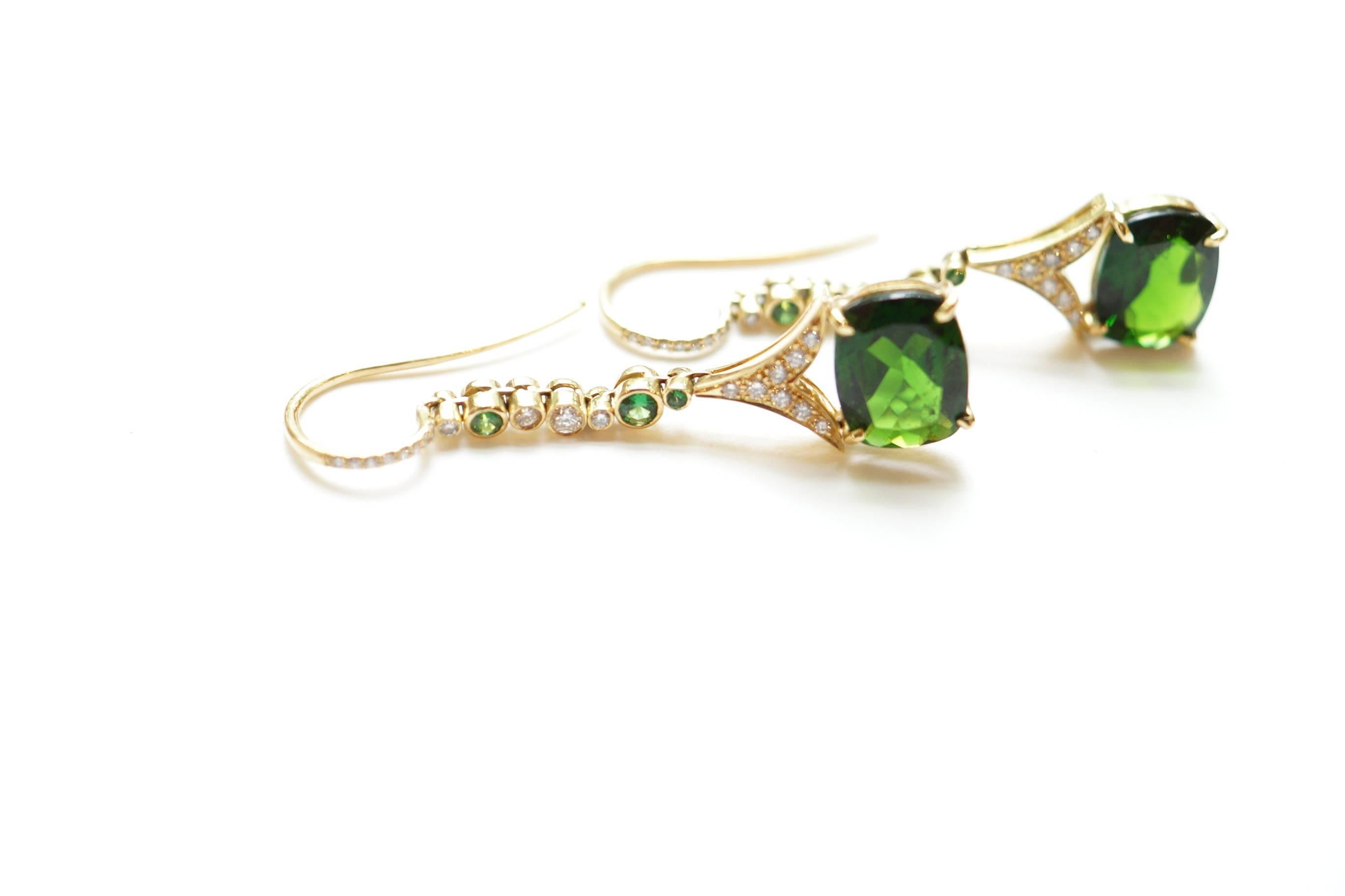 Lassa Eardrops
A pair of eighteen-karat yellow gold earpendants, showcasing a beautiful pair of rectangular emerald-cut chrome diopsides.  Suspended from each white diamond-encrusted earwire is a vertical line of sporadically placed tsavorite