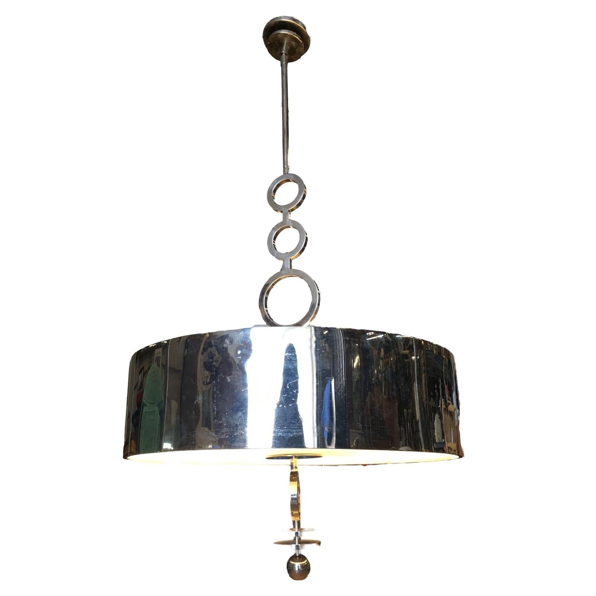 This modern drum chandelier features a chrome drum fixture with 6 standard light bulb sockets and frosted glass shade all suspended from a midcentury inspired 3 ring suspension pole.