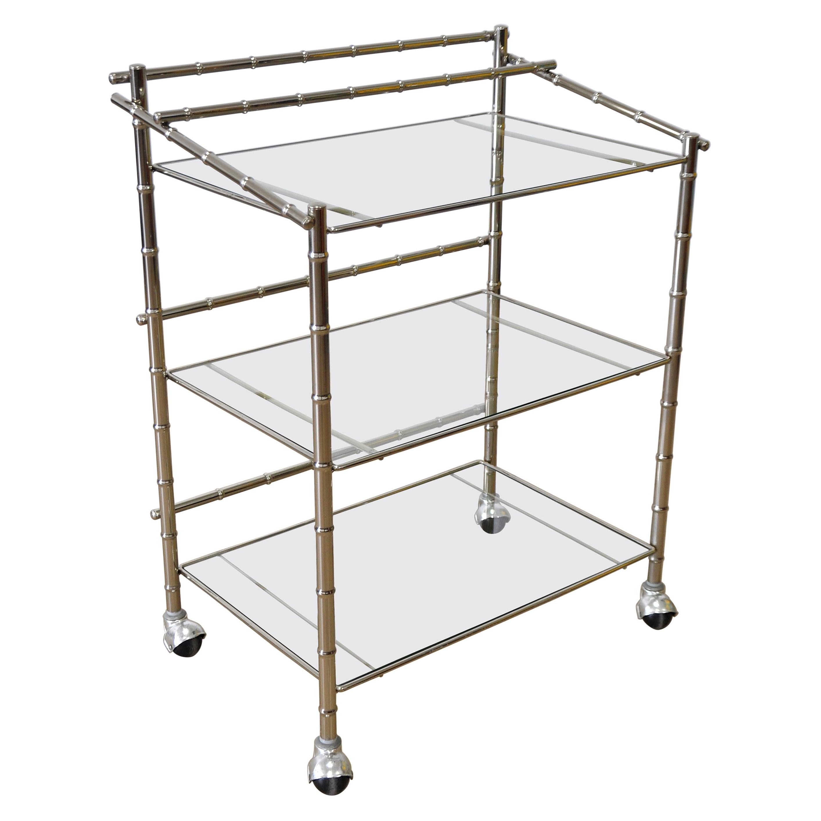A fabulous Hollywood Regency three-tier rolling serving trolley. The bar or tea cart features a chrome faux rattan frame and multiple tiers with inset clear glass. A stunning Mid-Century Modern design! Measures: Height to top tier 30 in.