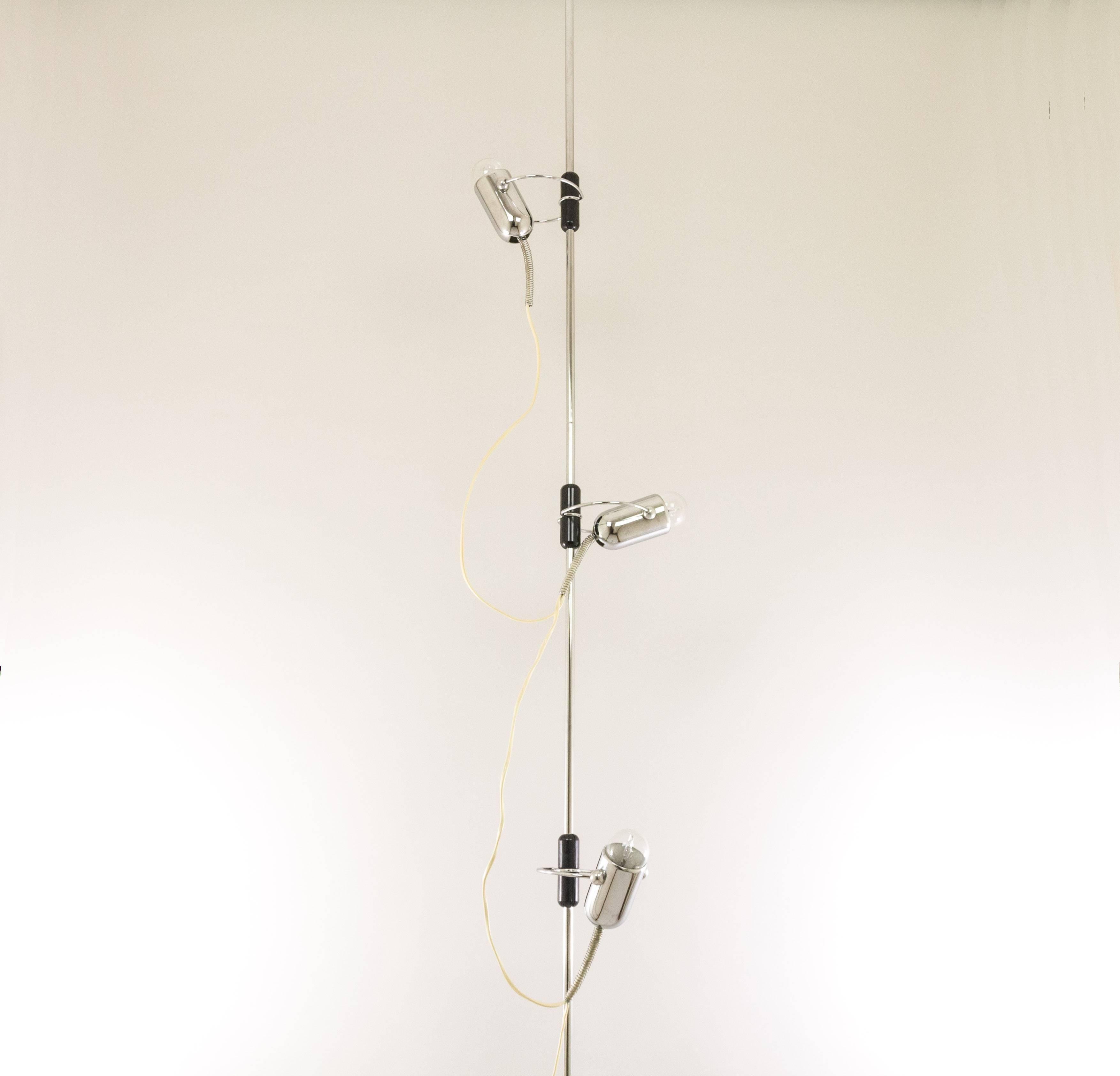 This lamp that stretches from floor to ceiling was designed during the 1960s by Francesco Fois and manufactured by Reggiani.

The construction exists of three equal 'rods' of each 90 cm long, two 'springs' of maximum 40 cm high and three chrome spot