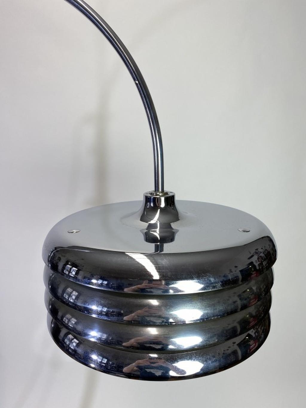 Floor lamp was designed by Tamás Borsfay and produced by the Hungarian Craftsmanship Company during the 1970s. The lamp features a layered disc lampshade on a chrome stem and solid base. The lampshade and half of the stem is adjustable.