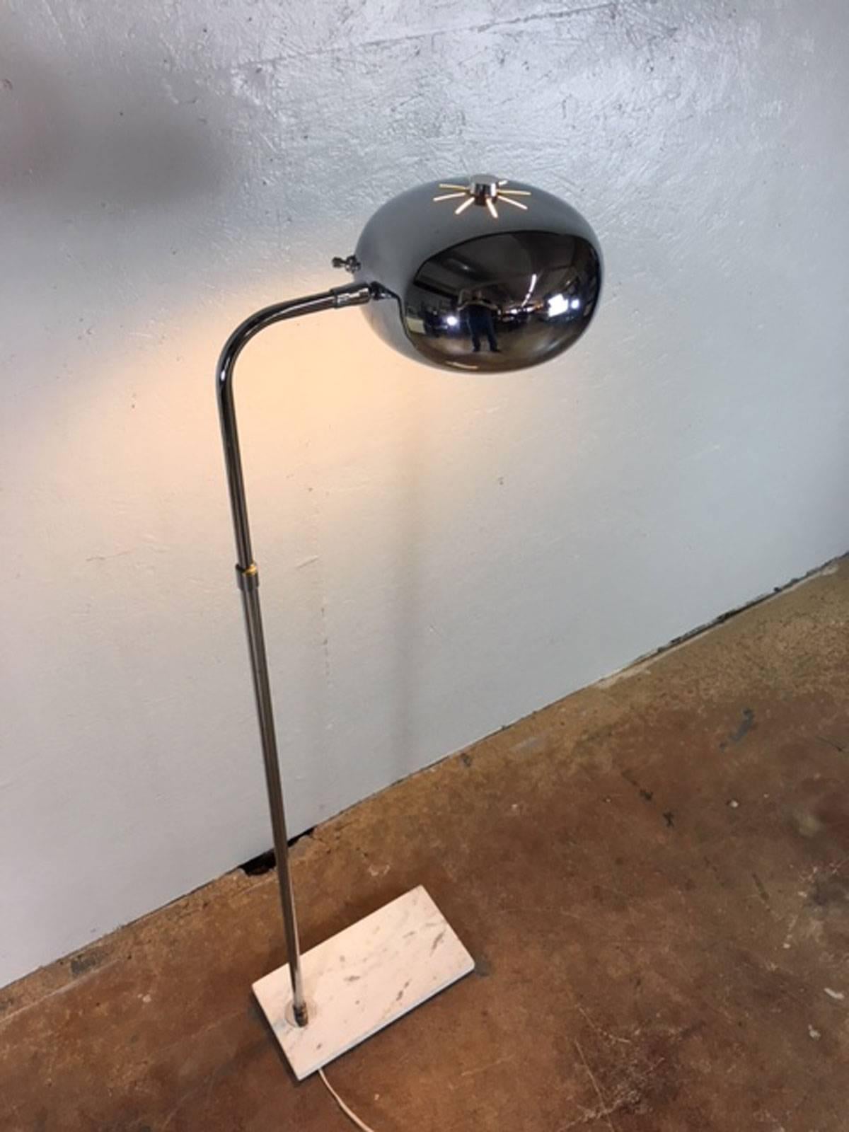 Chrome floor lamp on a marble base, circa 1960s. Works properly. Adjustable.