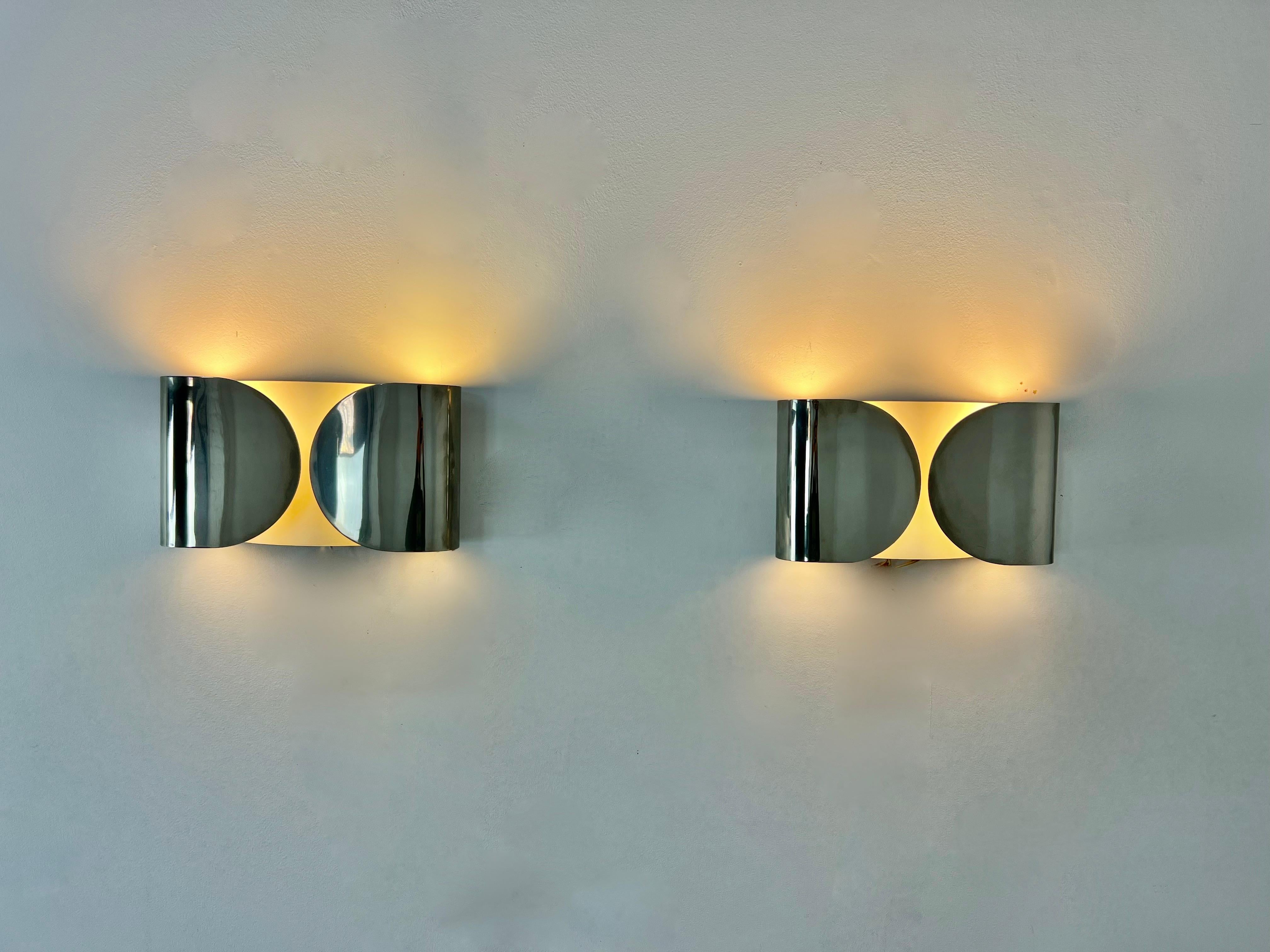 Pair of sconces in chrome metal. stamped. Wear due to time and age of the sconces.