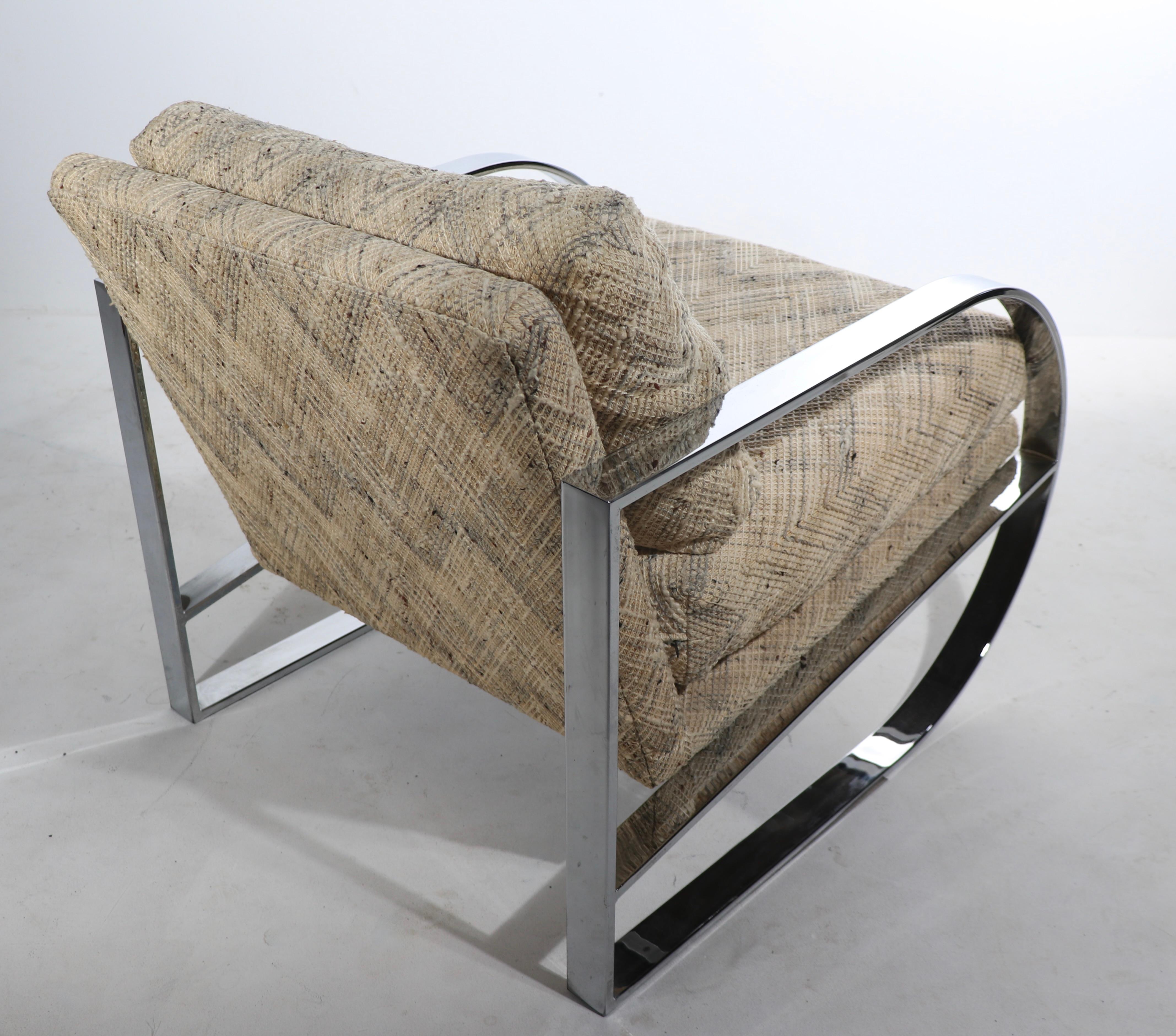 Fauteuil de club et de salon chic et élégant avec des éléments d'accoudoirs et de pieds continus en forme de D en chrome brillant et des sièges et dossiers rembourrés. Le fauteuil est en très bon état, original, propre et prêt à être utilisé. Motif
