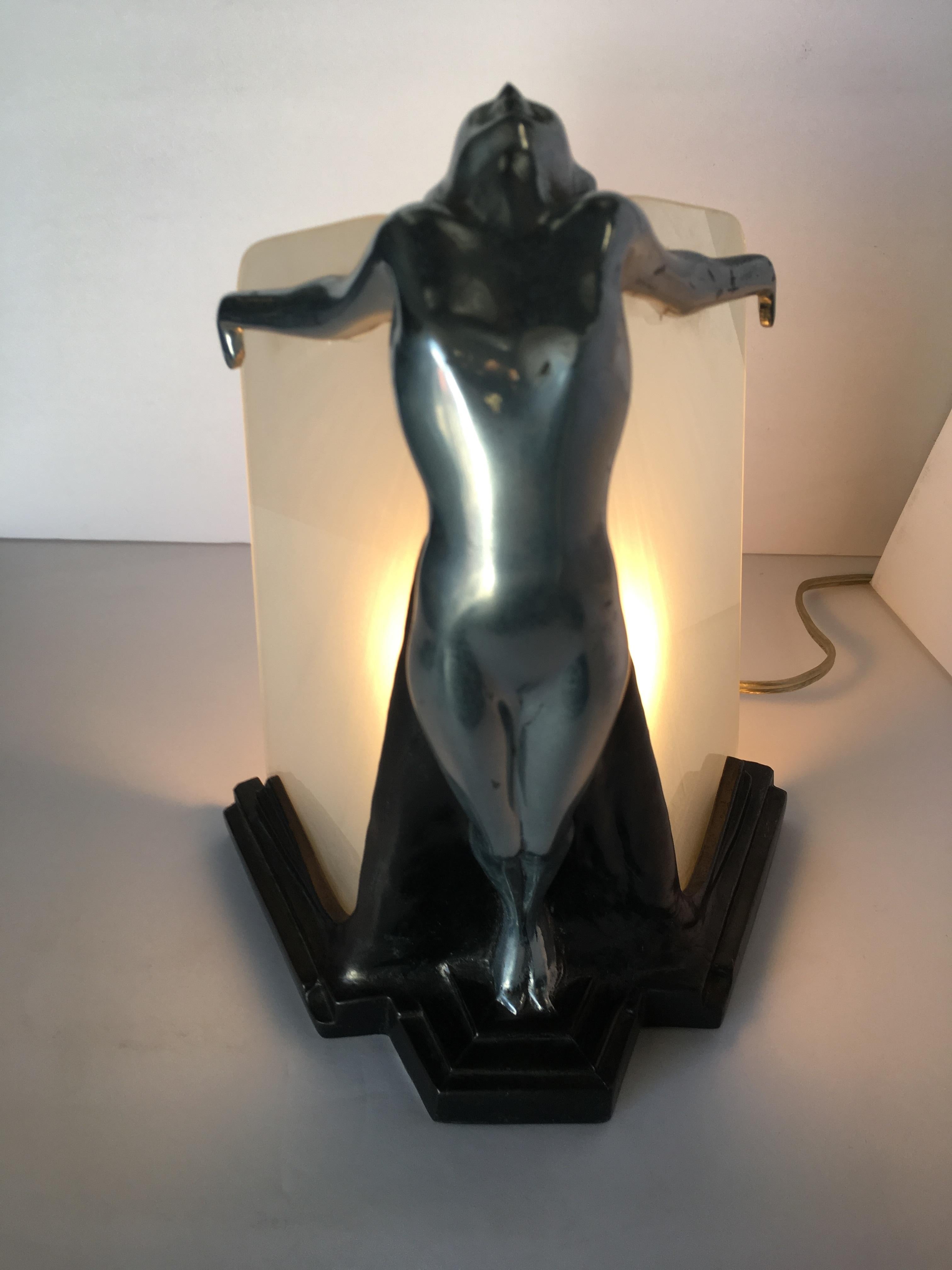 Chrome Frankart style table lamp featuring a nude female outstretched woman holding two glass plate lamp shades giving an almost wing-like appearance. Available 2, circa 1980, by Sarsaparilla.