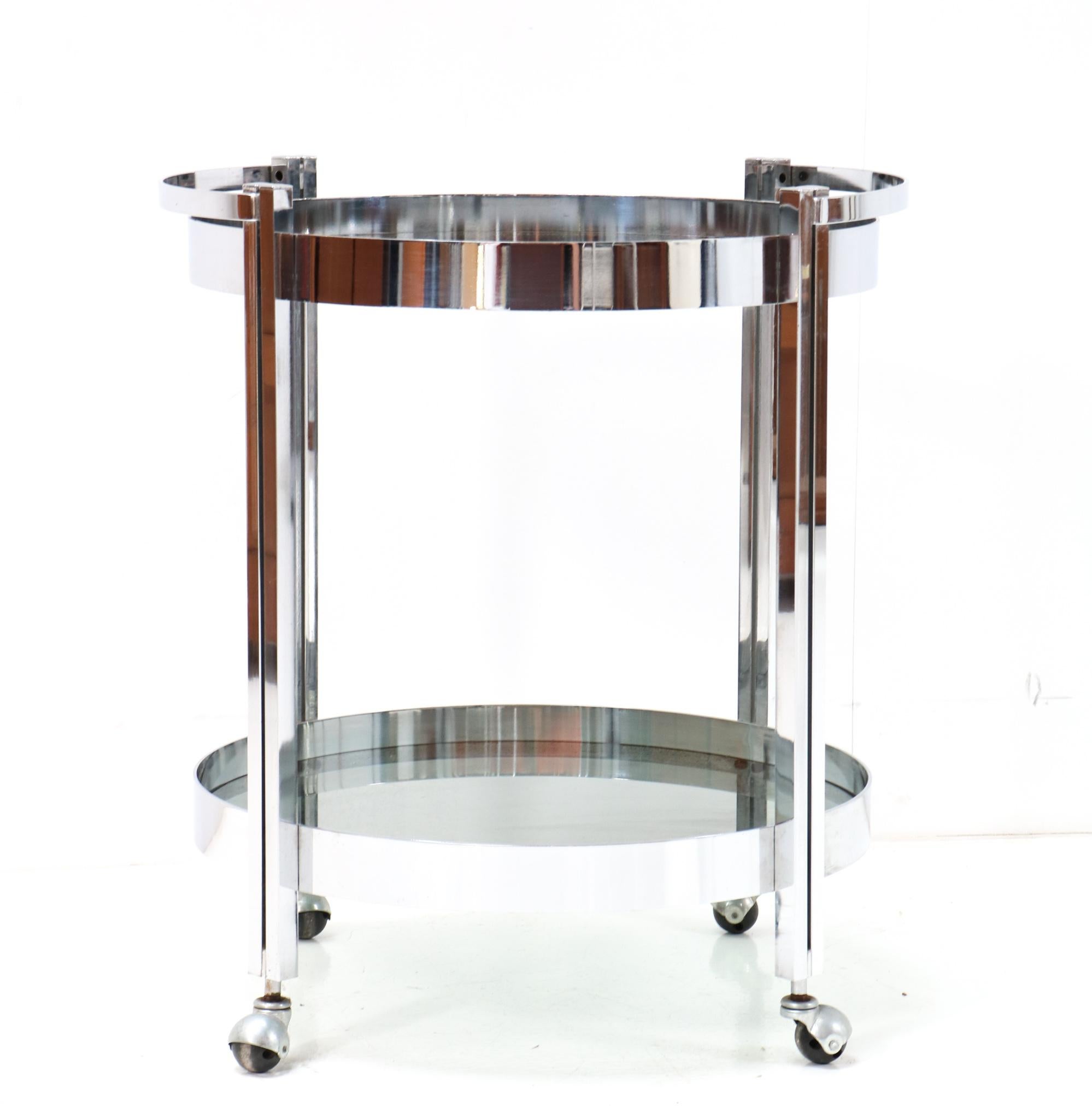 Funky Mid-Century Modern bar cart or trolley.
Striking French design from the 1970s.
Chrome plated metal frame with two original smoked glass tops.
This wonderful Mid-Century Modern bar cart or trolley is in good condition with
minor wear