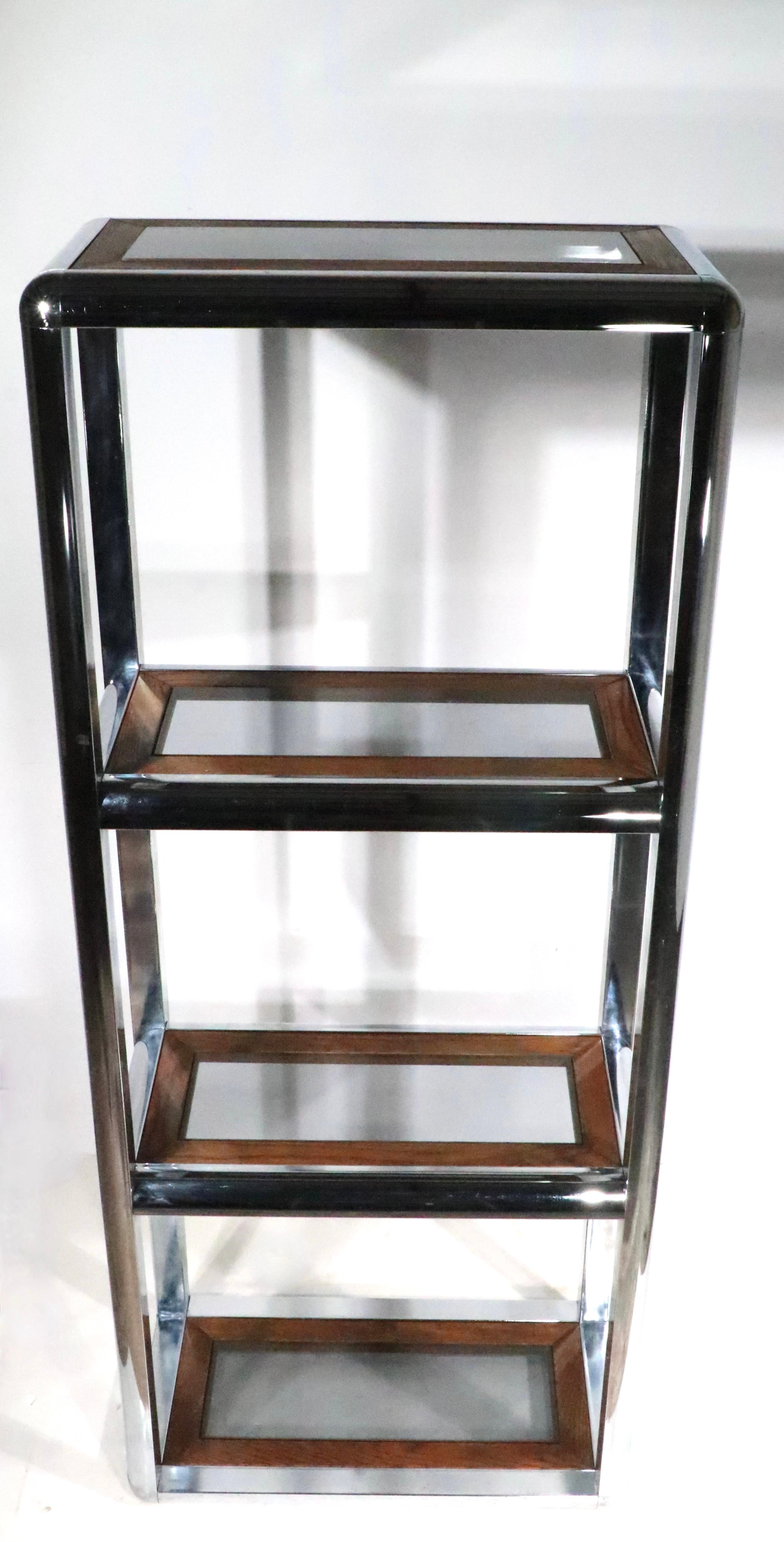 Voguish 1970's Mod chrome etagere shelf unit, with tinted glass insert shelves that rest in oak frames. The etagere features four shelves,  a  lower,   a second  ( 25 H ) Middle ( 48.5 H ) and Top ( 71.5 H ). The piece is in very good, original