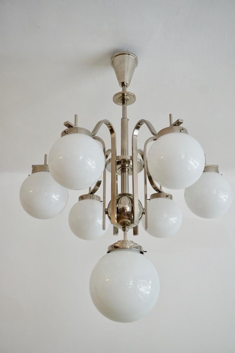 Chrome-glass Art Deco Chandelier from Hungary, from the 1930s

This is typical Hungarian Art Deco chandelier. Such elements of the design as iron ball on the central axis of the chandelier or the curved of side globes are referring to the Baroque