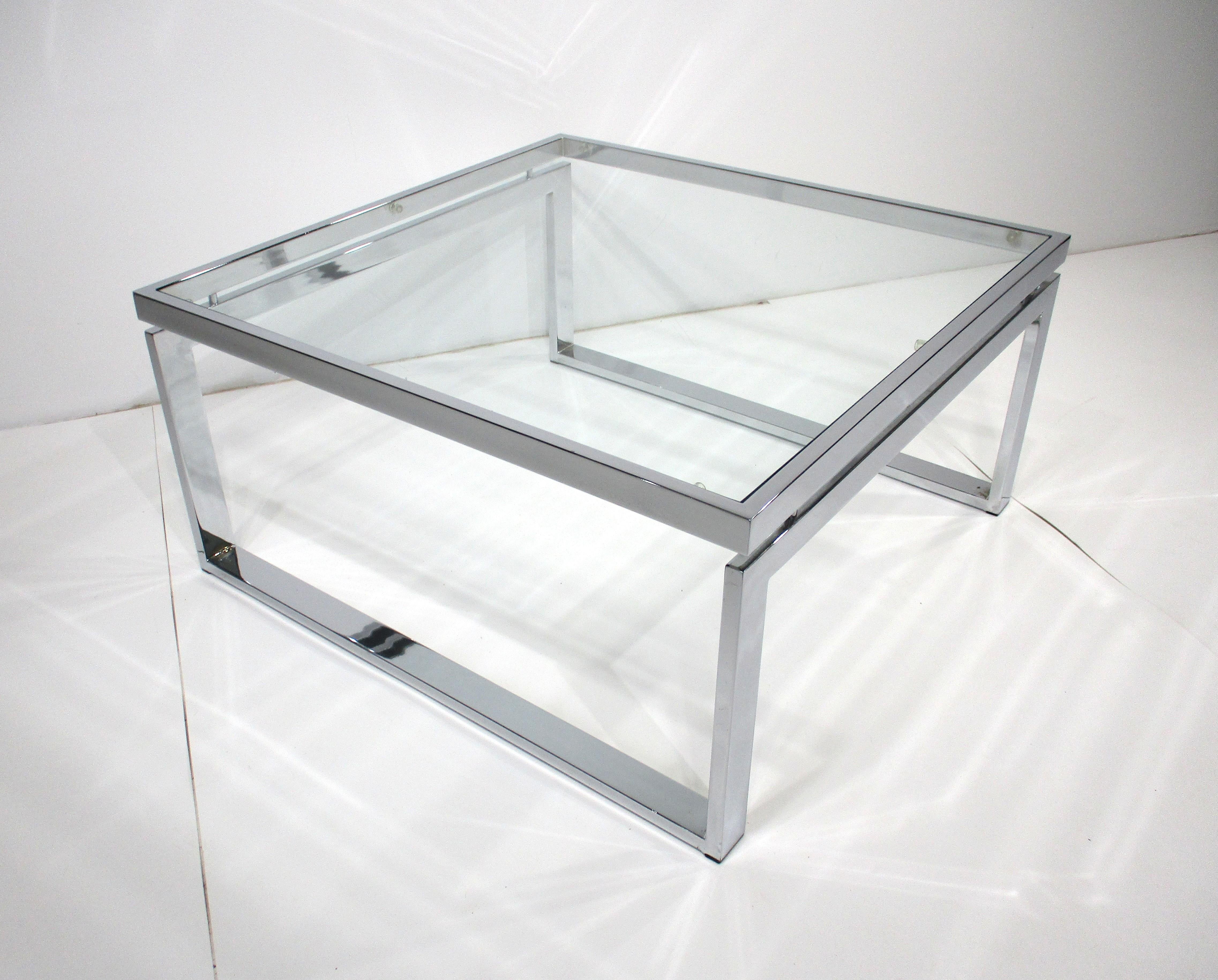 Ein verchromter Mid-Century-Metall-Couchtisch mit einem erhöhten, schwebenden Abschnitt mit einer Glasplatte. Eine sehr saubere, anspruchsvolle Form A in der perfekten Größe für das Wohnzimmer, den Unterhaltungsbereich oder das Wohnzimmer. Entworfen