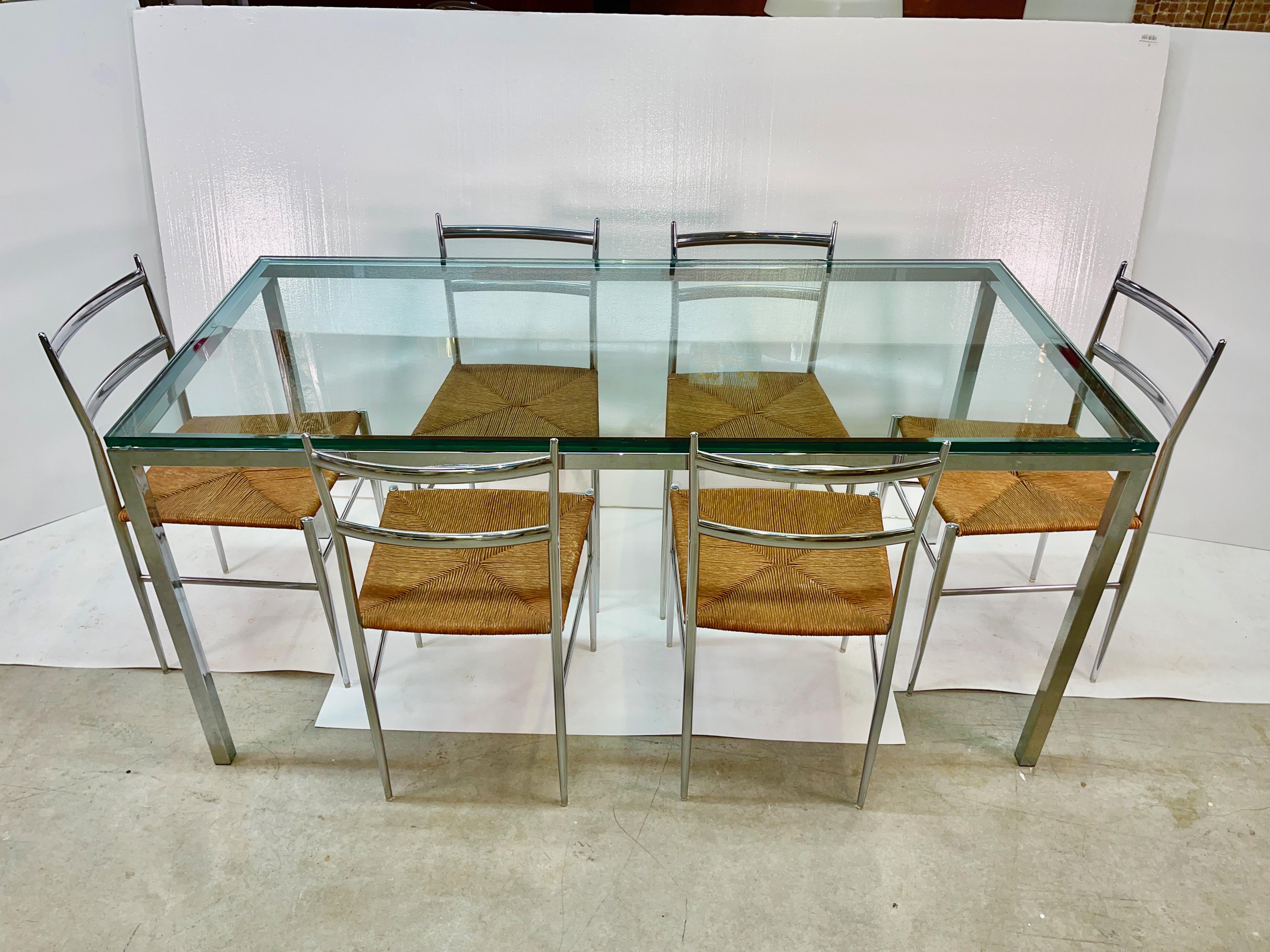 1970's chrome-a-licious dining table and chairs imported from Italy.
This slim dining table is of minimalist rectangular form and made of chromed steel square tube.
The 3/4 inch thick glass top rests flush to the edge with no overhang. Flat