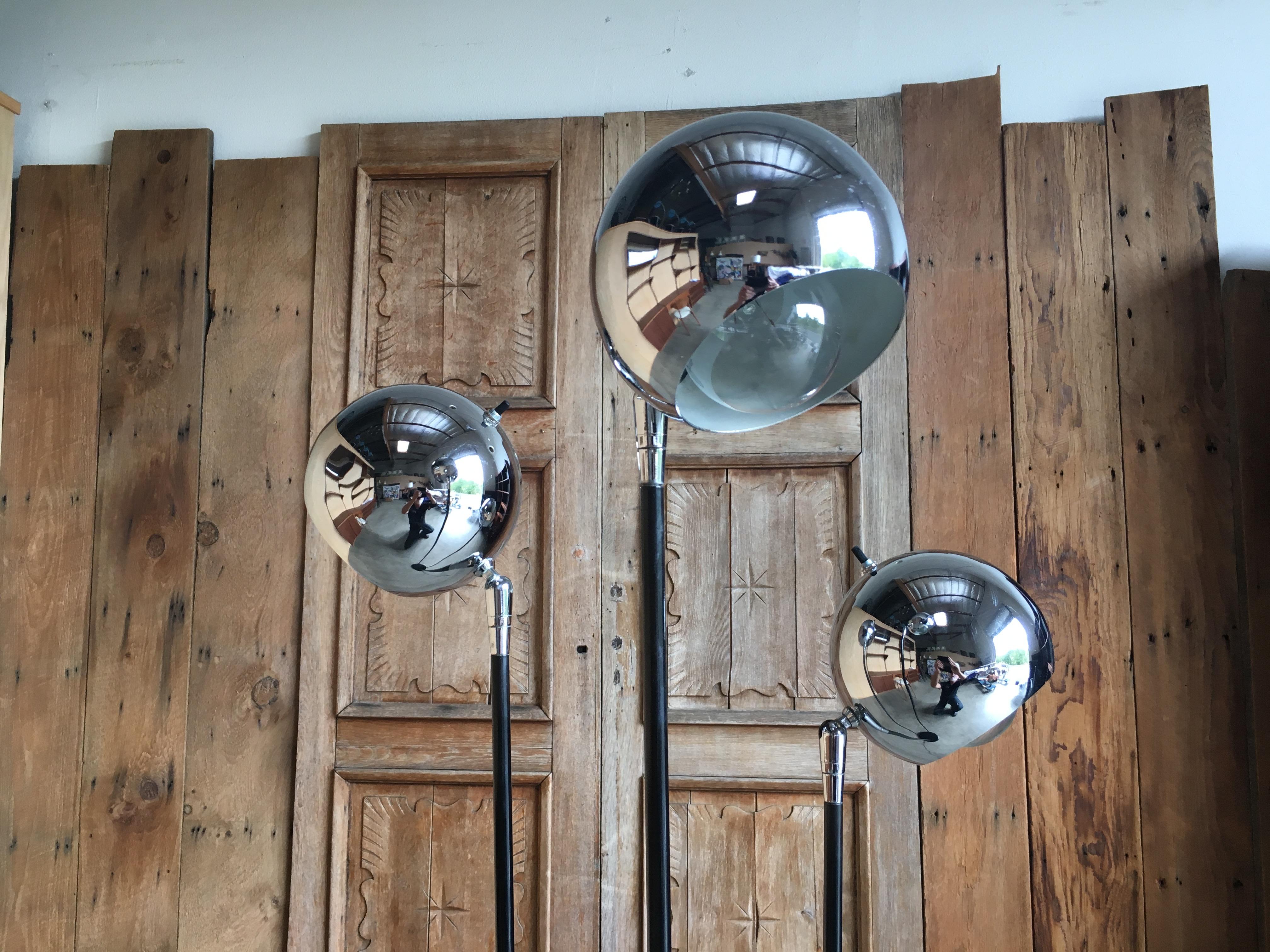 Black painted base and arms leading to three chrome globes that are adjustable.