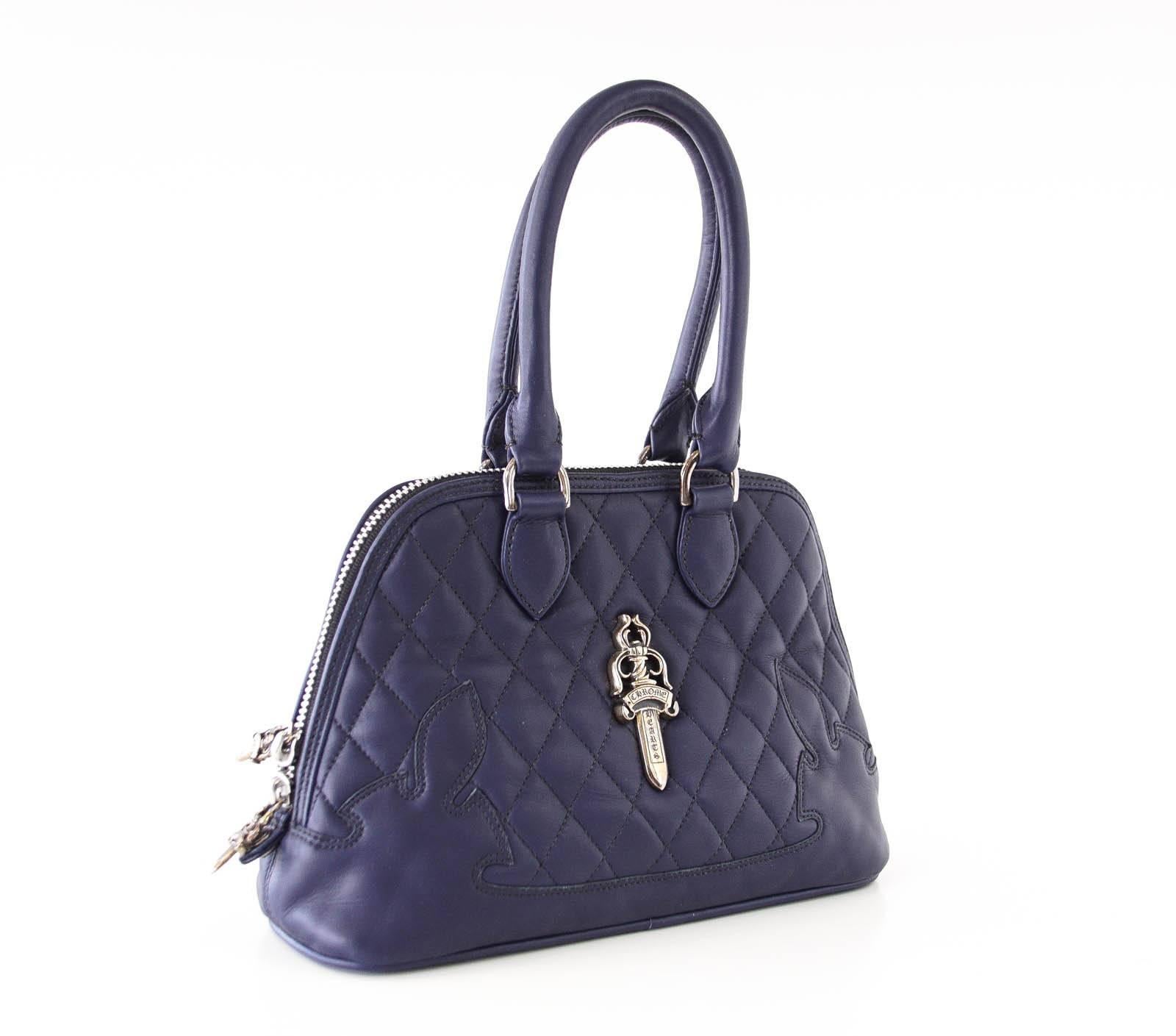 Guaranteed authentic Navy quilted Chrome Hearts charming bag with stitched logo at corners.
Signature Silver logo plaque in front and rear embossed name.
Top zip with logo pull. All hardware is sterling silver.
Top rounded leather handles.
Interior