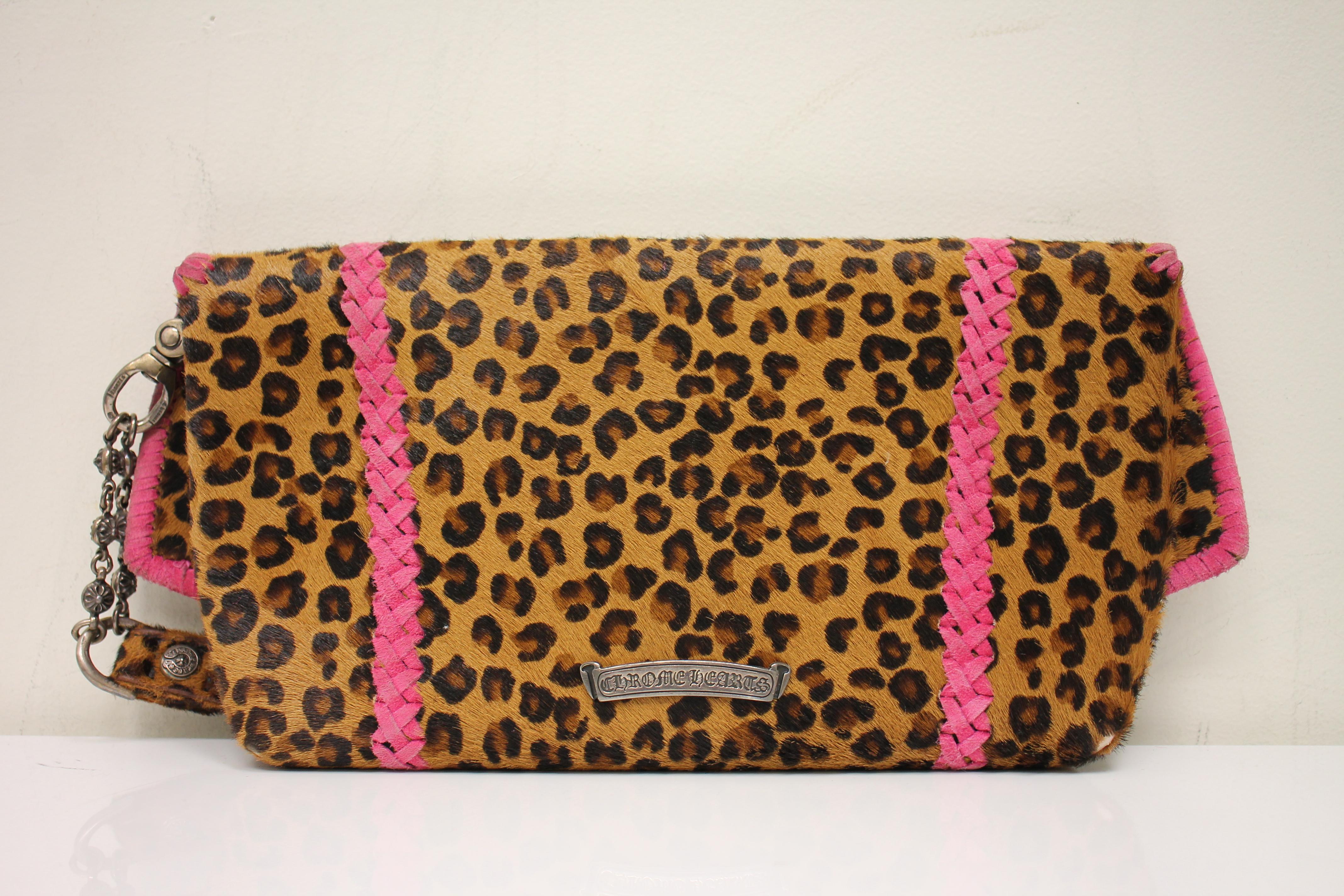Cheetah calfskin. Silver-tone hardware. Pink suede trim and detail throughout. Front flap with magnetic snap closure feturing hardware logo at front. Detachable wrist strap at side. Lined interior. One interior opened pocket.