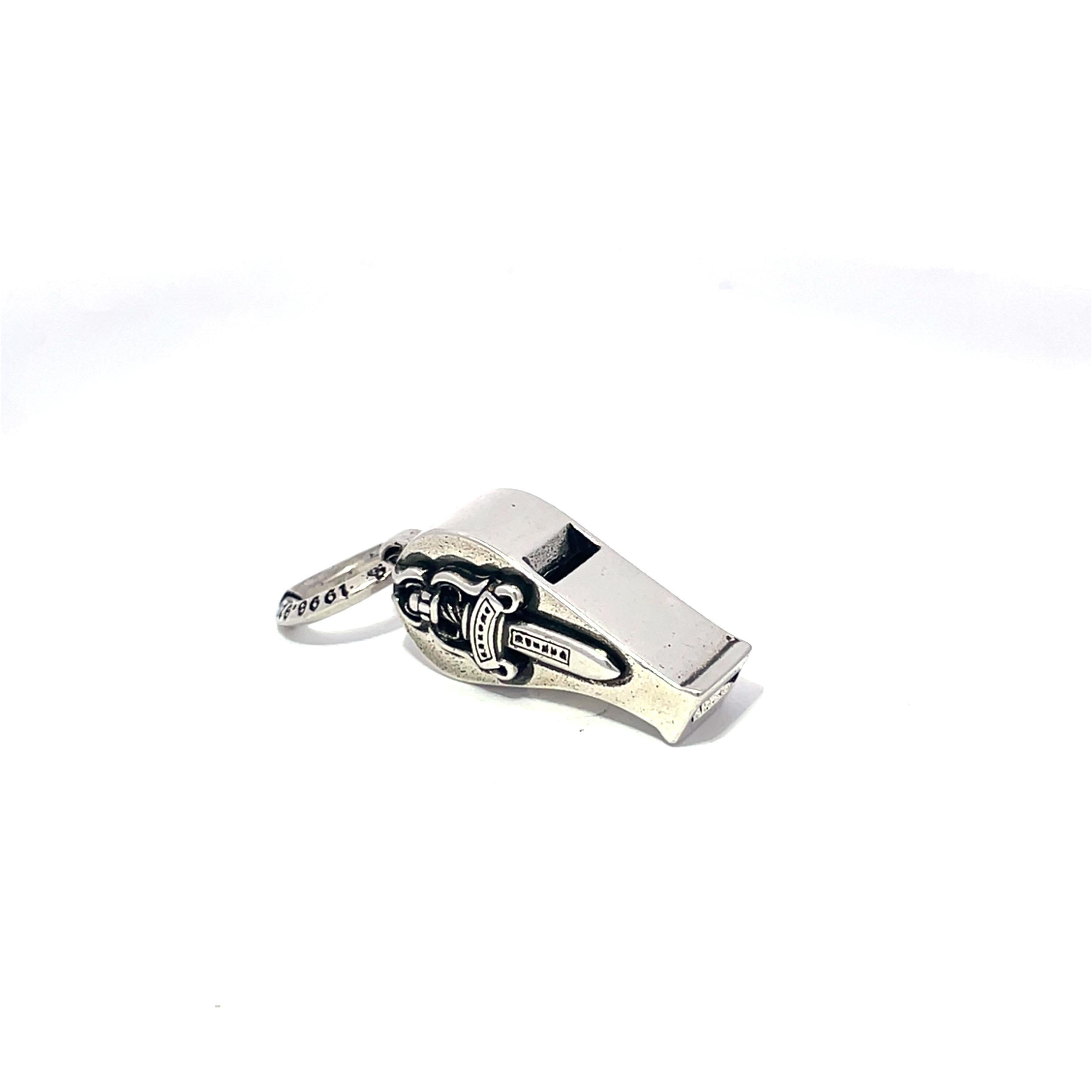 Te presentamos el charm silbato de plata de ley Chrome Hearts, una pieza única que combina a la perfección arte y funcionalidad. Fabricado en plata de ley S925 de alta calidad, este pequeño pero llamativo silbato mide 2,54 cm de largo y 0,8 cm de