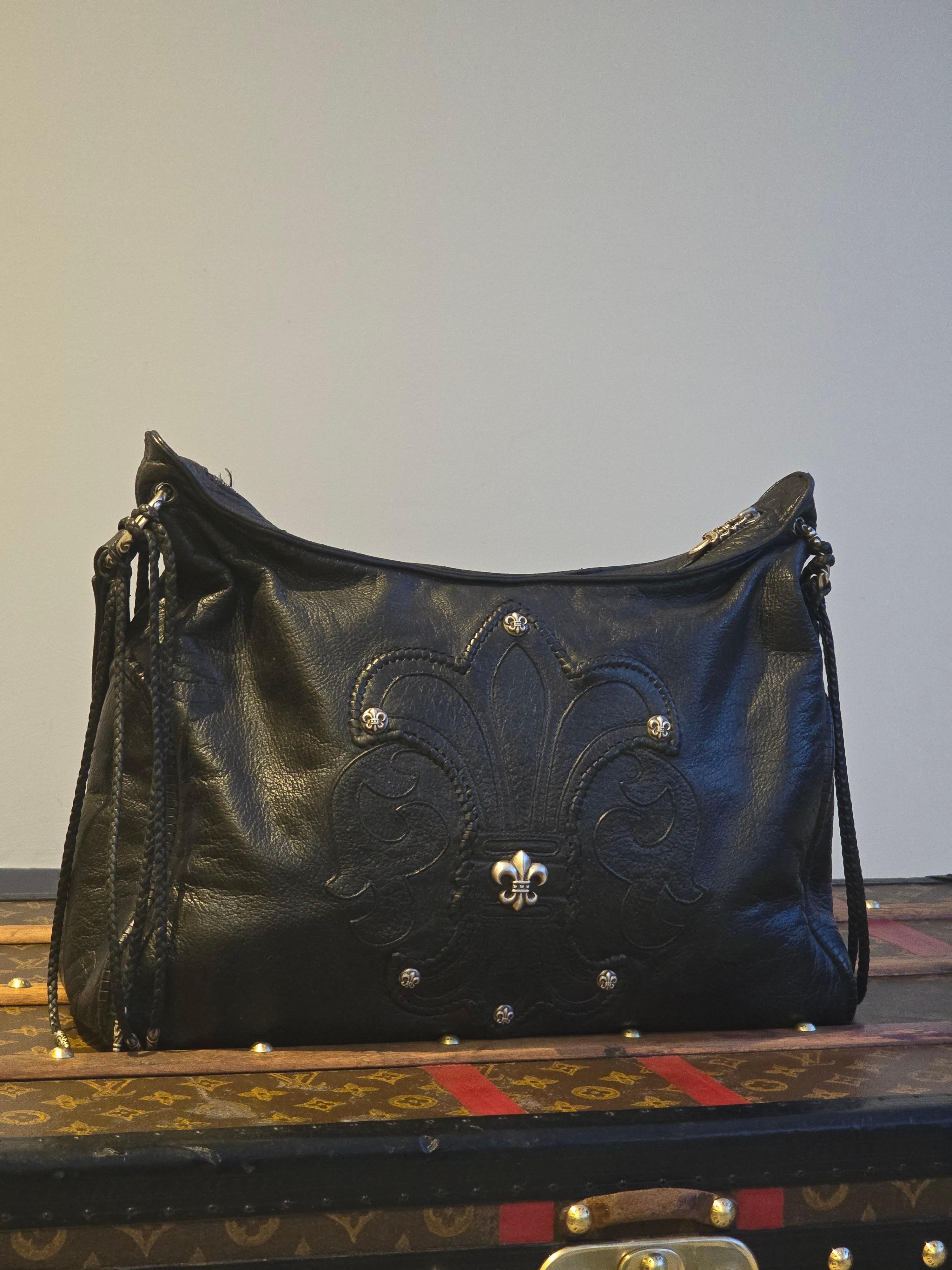 Immerse yourself in the epitome of edgy luxury with the Chrome Hearts Fleur De Lis Hobo Bag, a statement piece that melds the rebellious spirit of Chrome Hearts with the timeless elegance of high-end fashion. This exquisite bag is designed for those