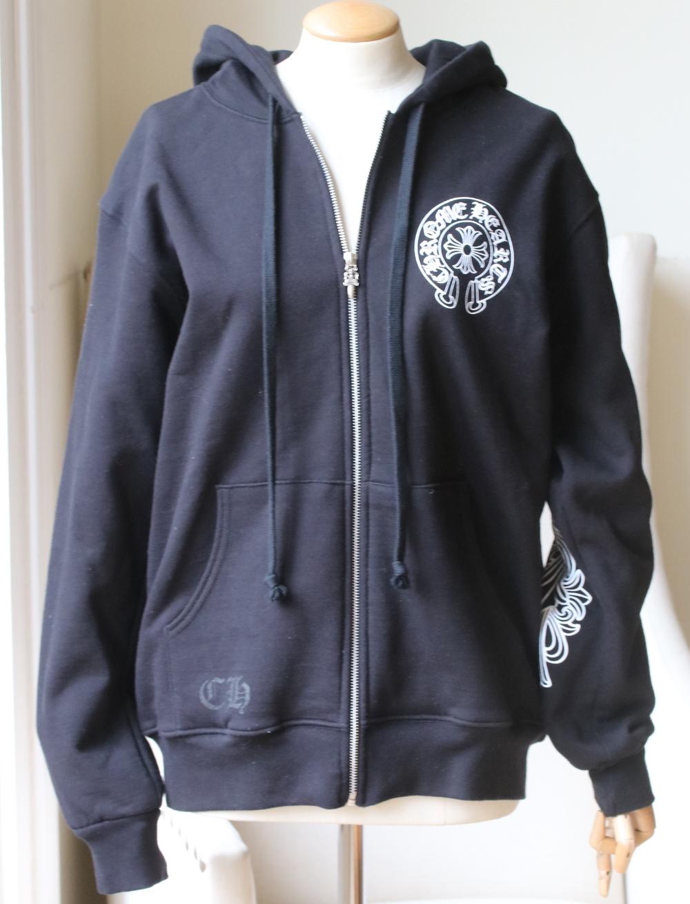 Long sleeve cotton jersey hooded zip-up sweatshirt in black by Chrome Hearts. 
Logo printed in white. 
Printed detail on the back and down the sleeves. 
Rib knit collar, cuffs and hem. 
Zip-up fastening. 
Colour: black. 
100% Cotton. 

Size: Medium