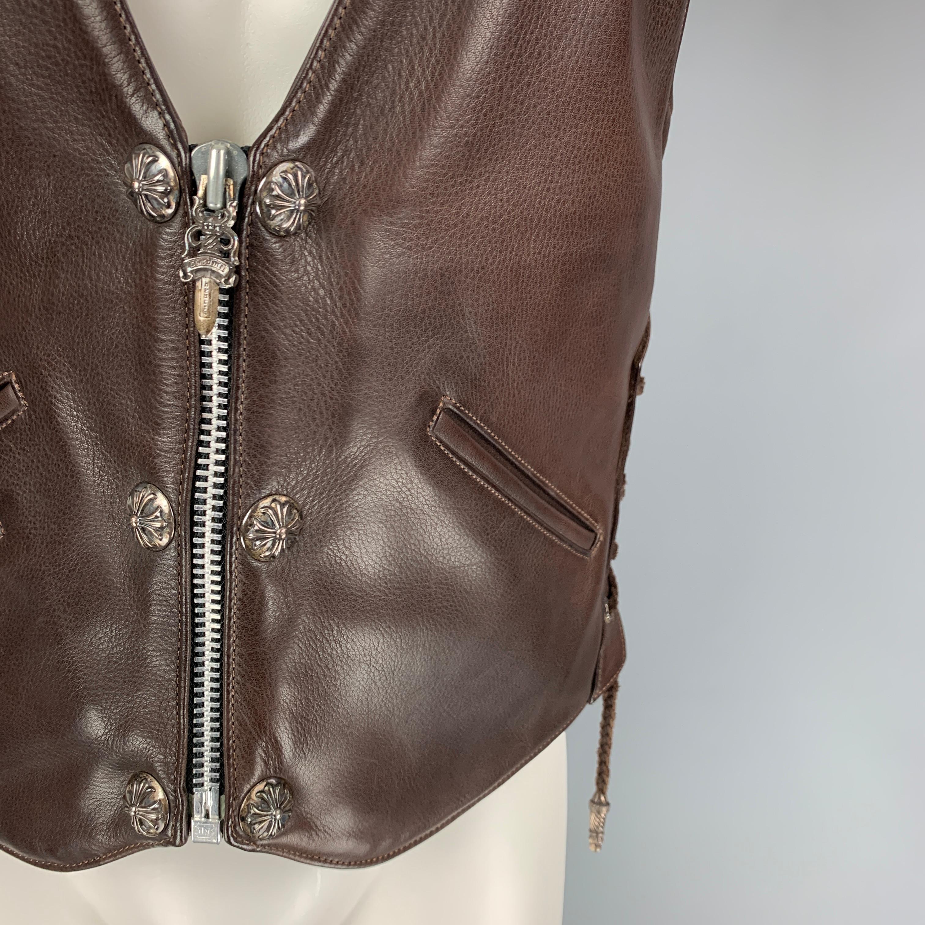 CHROME HEARTS vest comes in a thick lux brown leather with a full liner featuring side braided strap detail, silver tone hardware, one internal zip pocket, front silt pockets, back strap, and signature dagger zip up YKK closure. Made in USA. 

Very