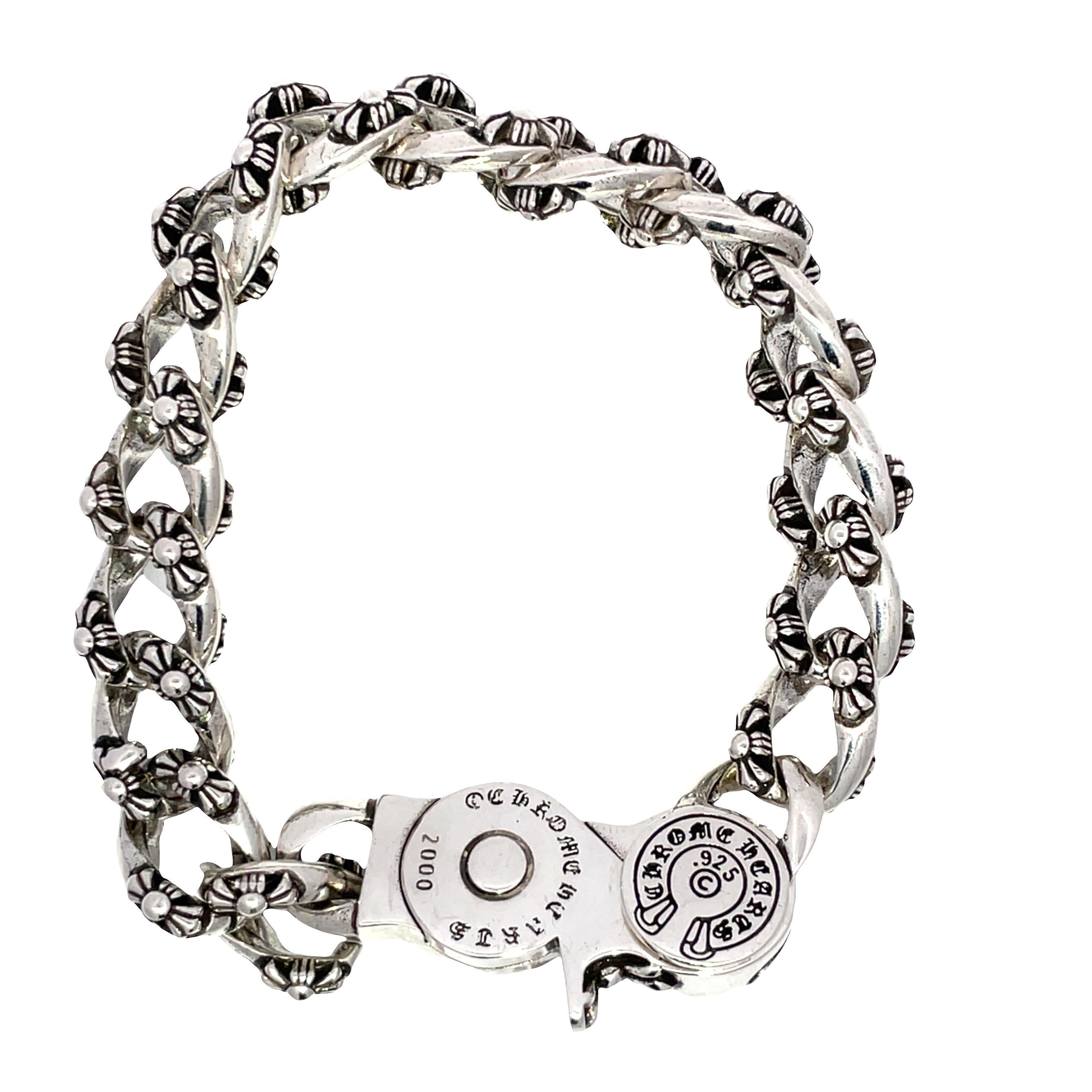Elevate your accessory game with this exquisite sterling silver chain bracelet, a stunning piece from the year 2000 that showcases a unique Cuban chain design. Each link is meticulously adorned with intricate floral motifs, creating a continuous and