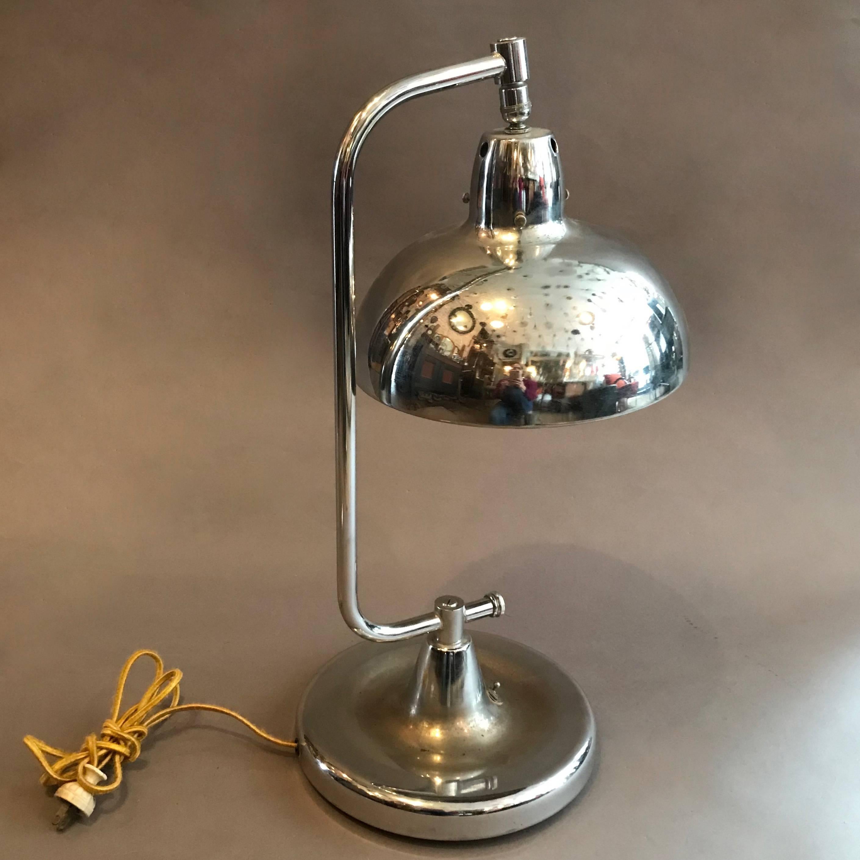 Chrome jeweler's table lamp by Apollo features an articulating shade is newly wired to accept up to a 150 watt bulb. The base is 9.5 inches diameter. We have a second one listed separately.