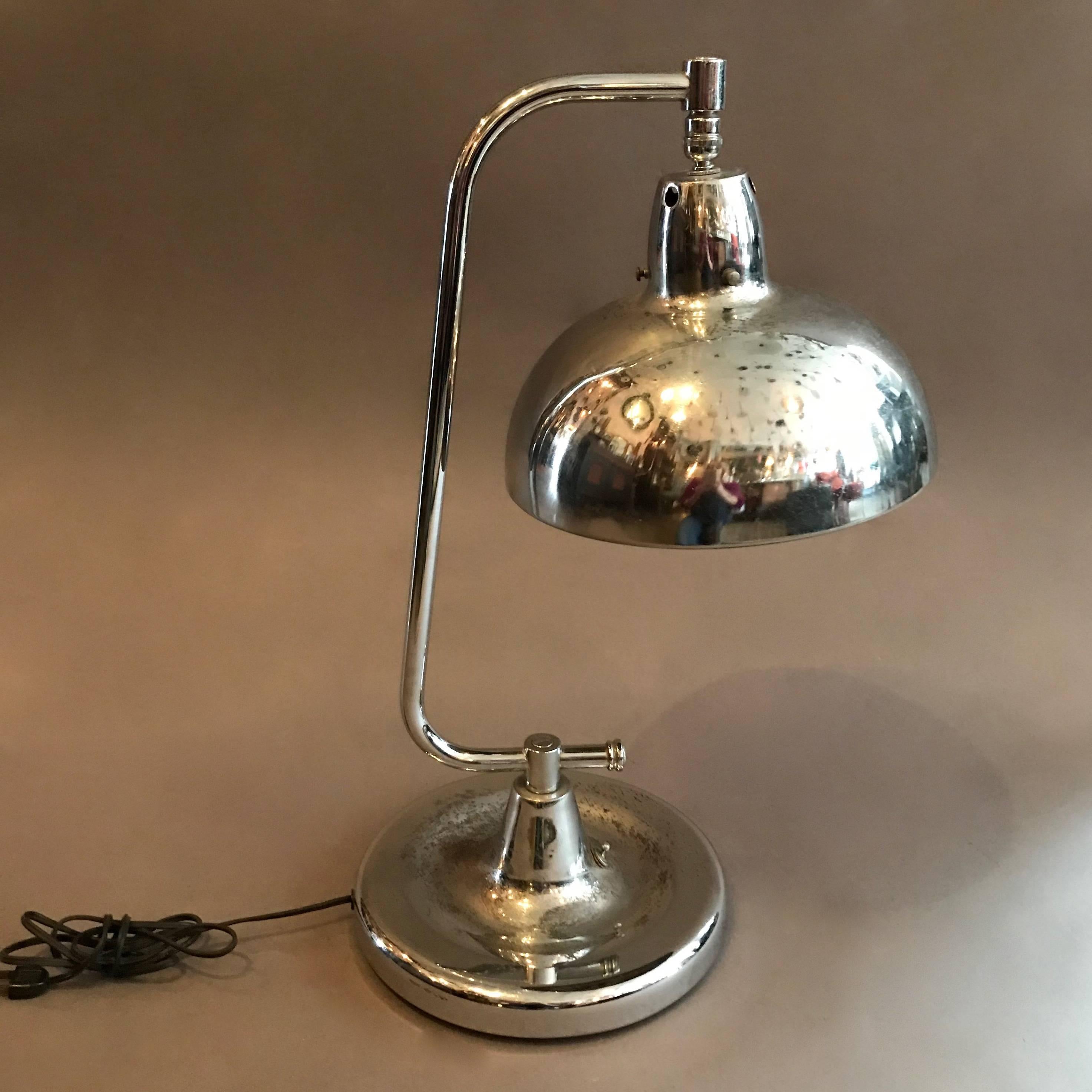 Chrome jeweler's table lamp by Apollo features an articulating shade is newly wired to accept up to a 150 watt bulb. The base is 9.5 inches diameter. We have a second one listed separately.