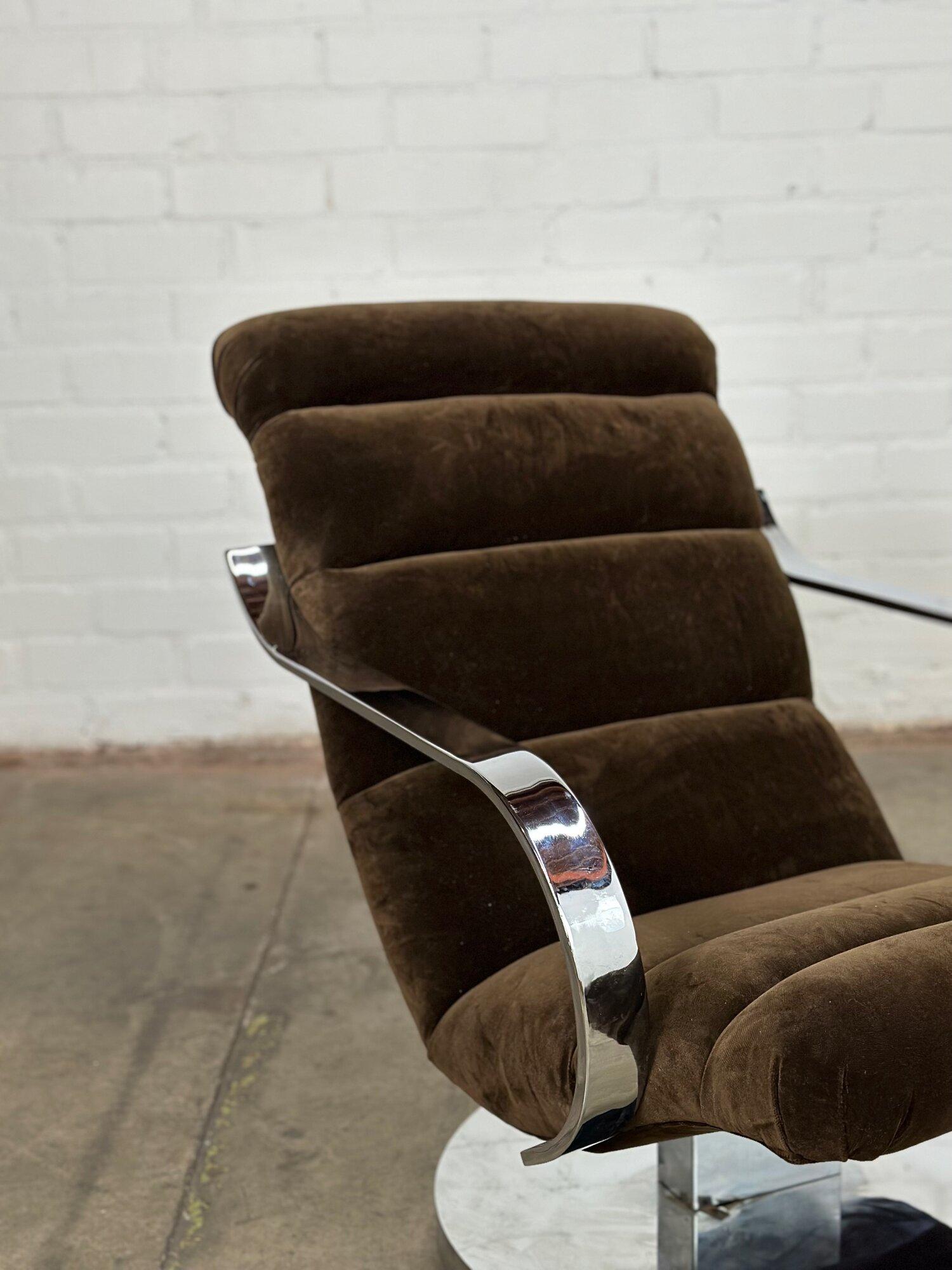 Measures: W26 D38 H31 SW21 SD19 SH16 AH21

Vintage chrome and chocolate velvet lounger reminiscent of the waive chaise by Milo Baughman. Chair swivels and slightly reclines and features a chrome base and frame with minimal patina. Item is
